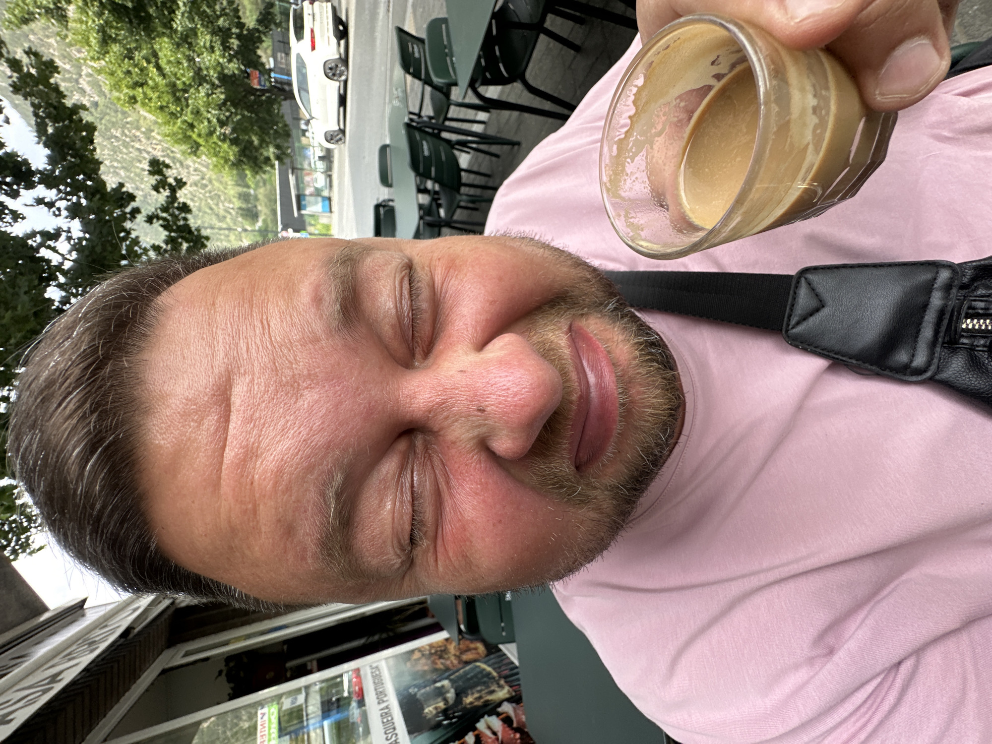 Man enjoys coffee at Andorra cafe, moth spotted nearby