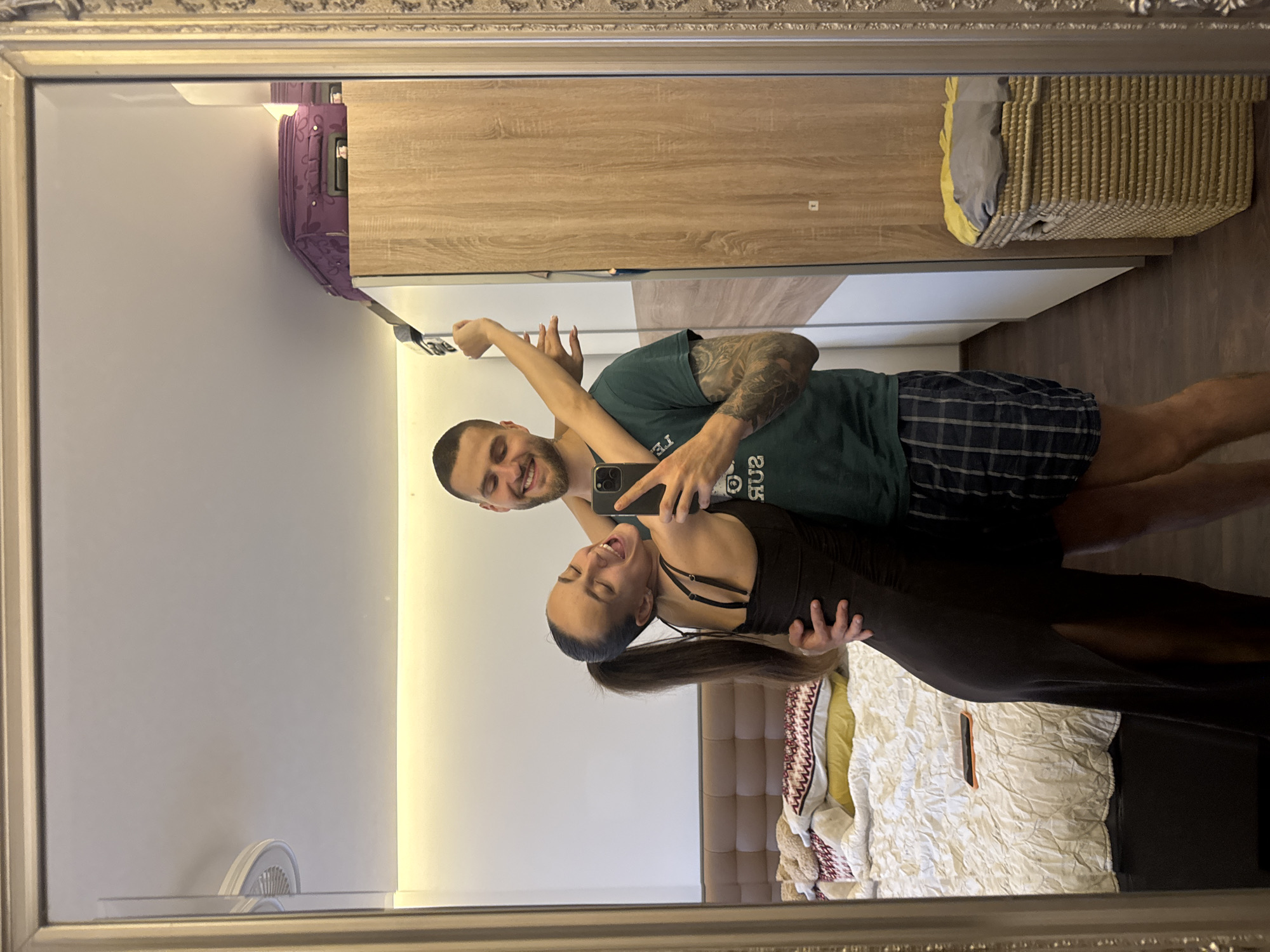 Couple takes mirror selfies in Sofia bedroom