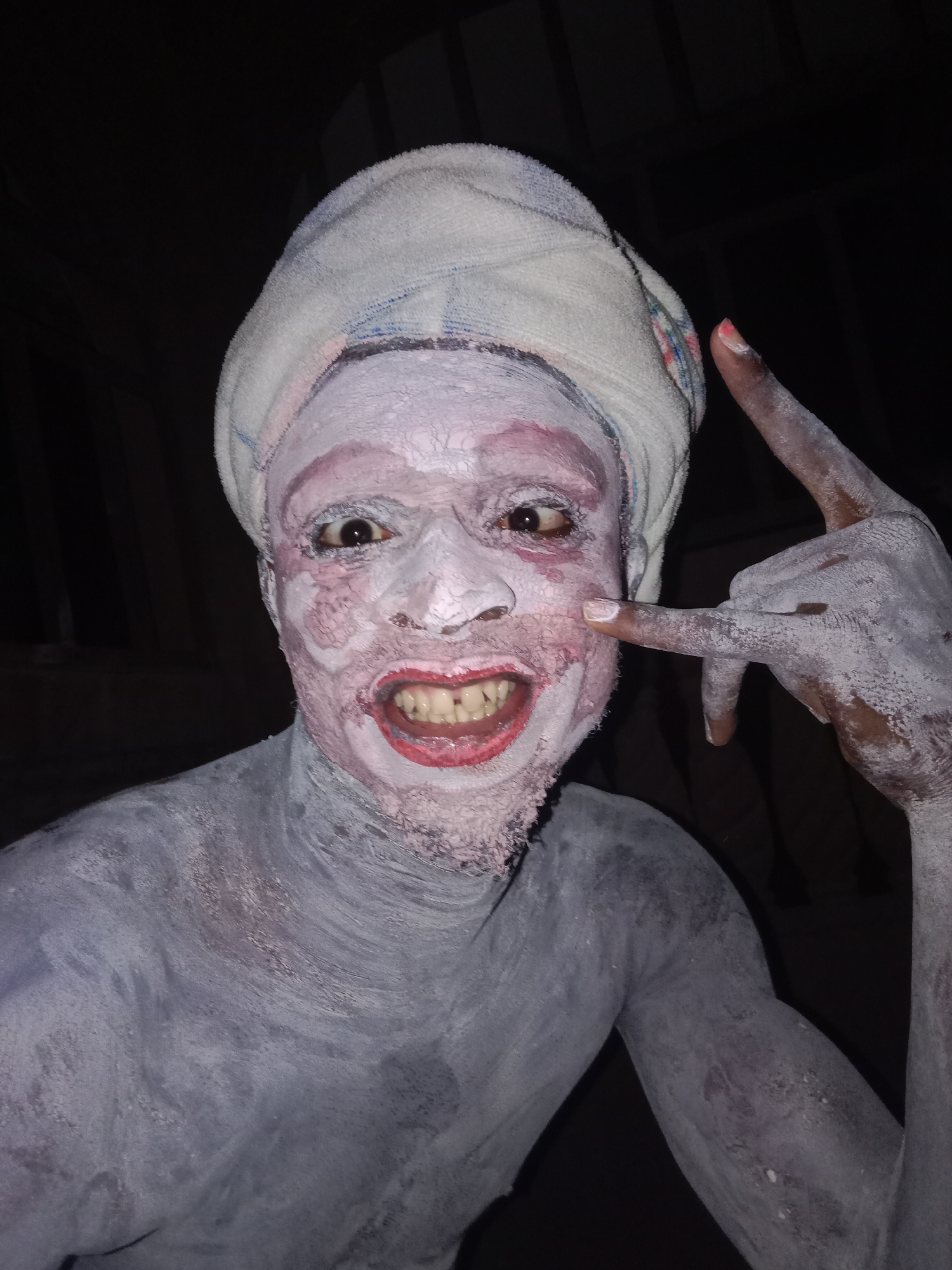 Paint-covered person performs gestures in unknown location