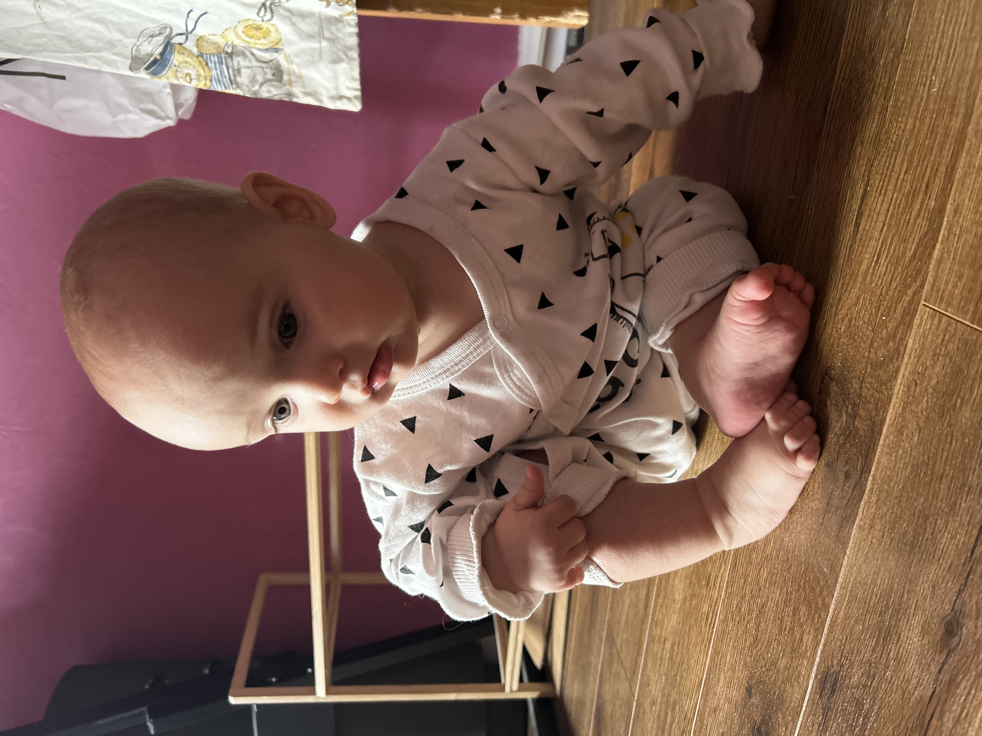 Baby plays on wooden floor in Moscow home