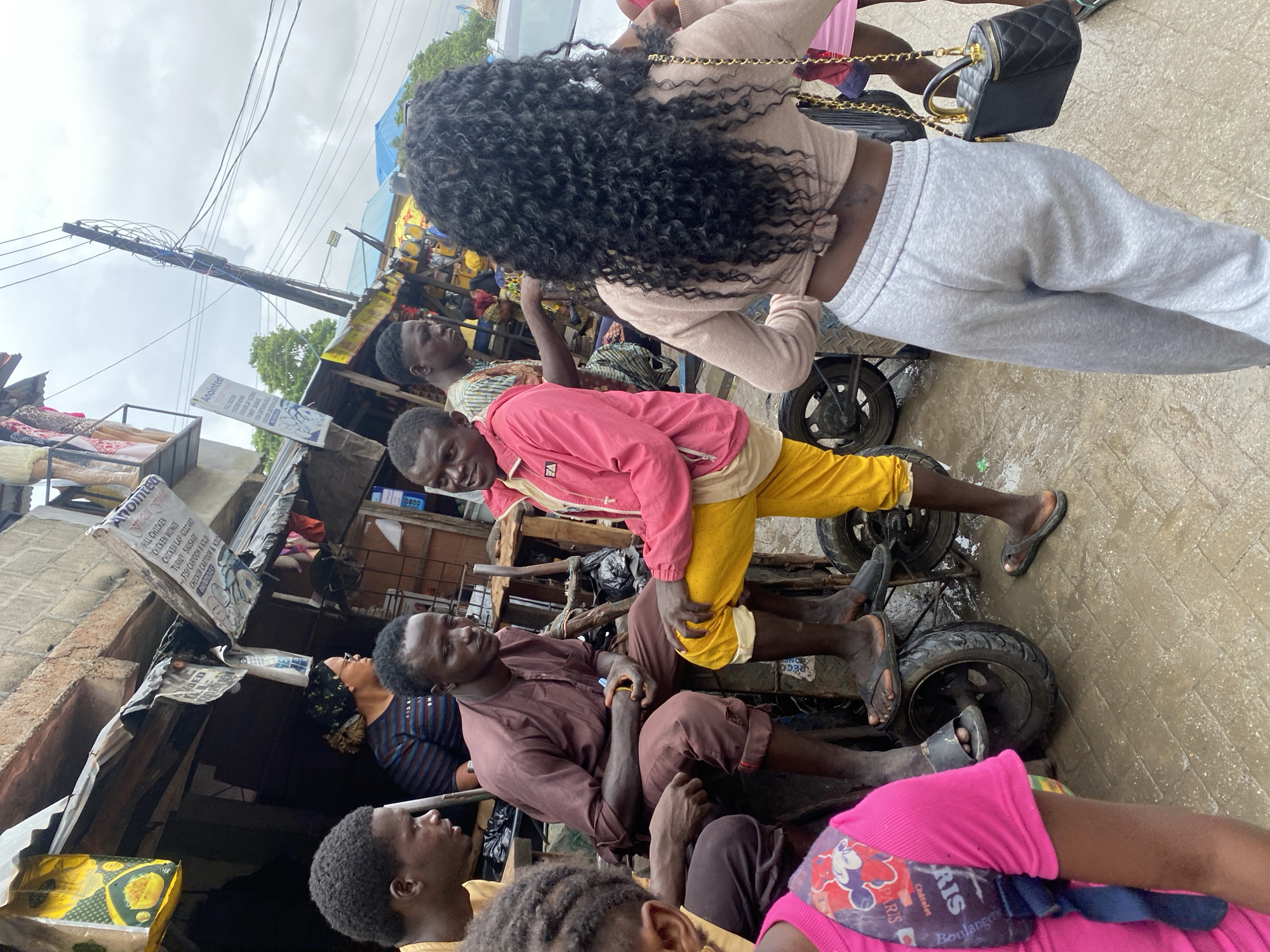 Busy outdoor market with vendors, produce, and workers moving through