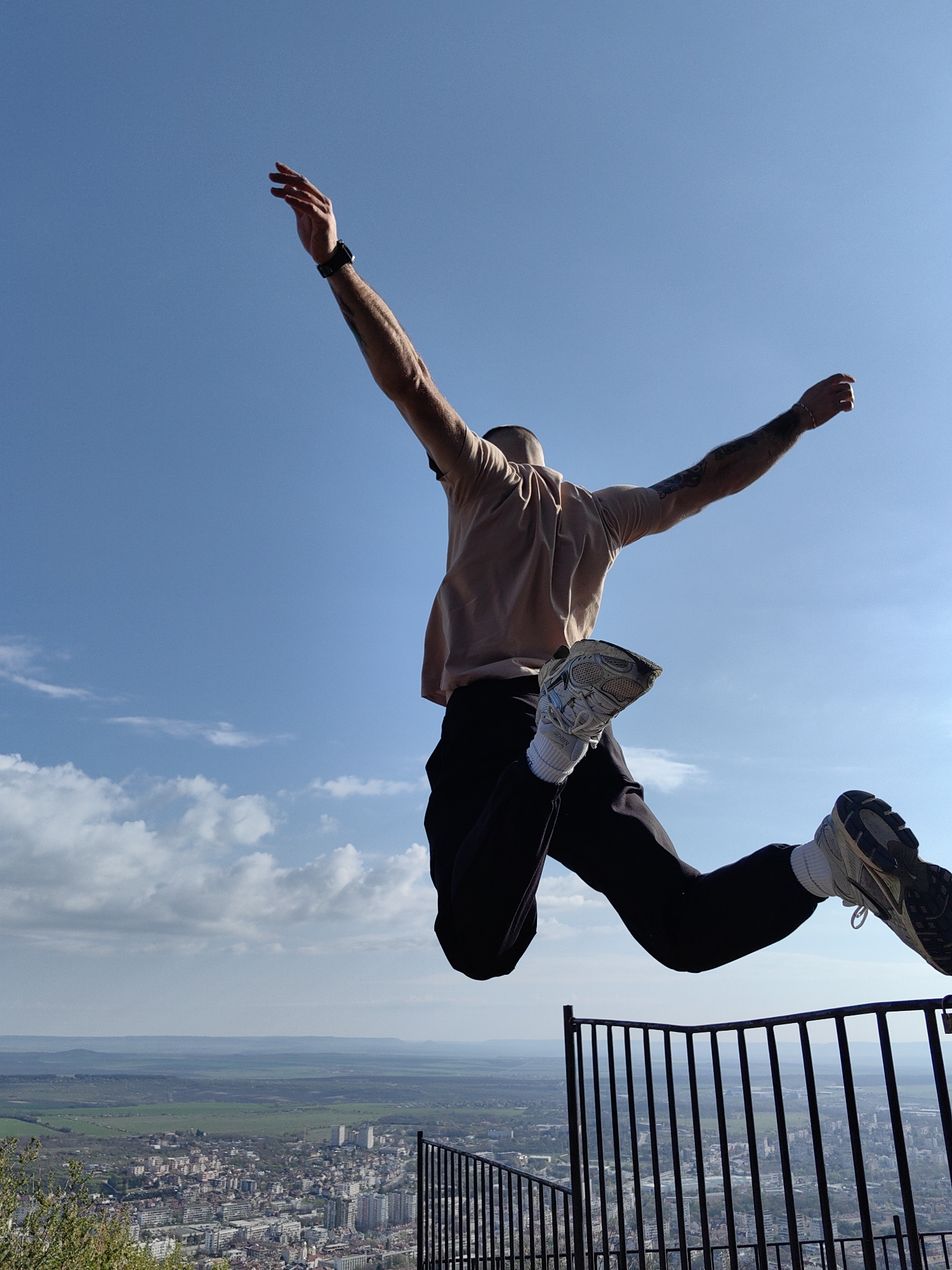 Person celebrates with jump against Shumen cityscape