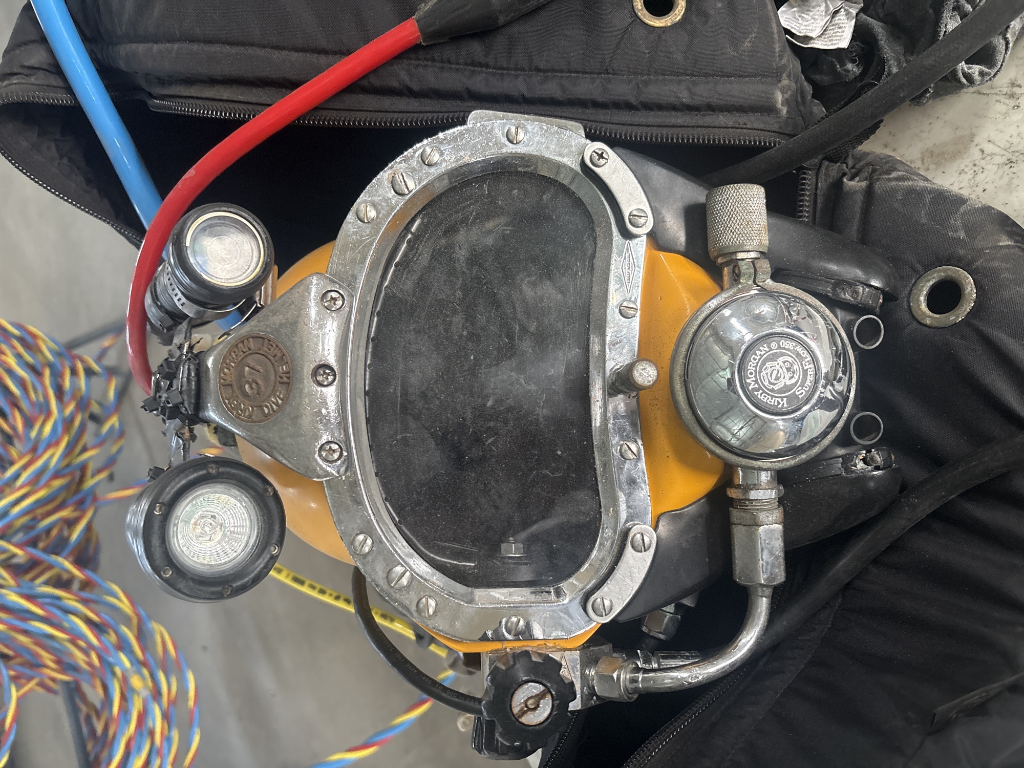 Vintage Kirby Morgan dive helmet resting on a duffel bag, Baku
