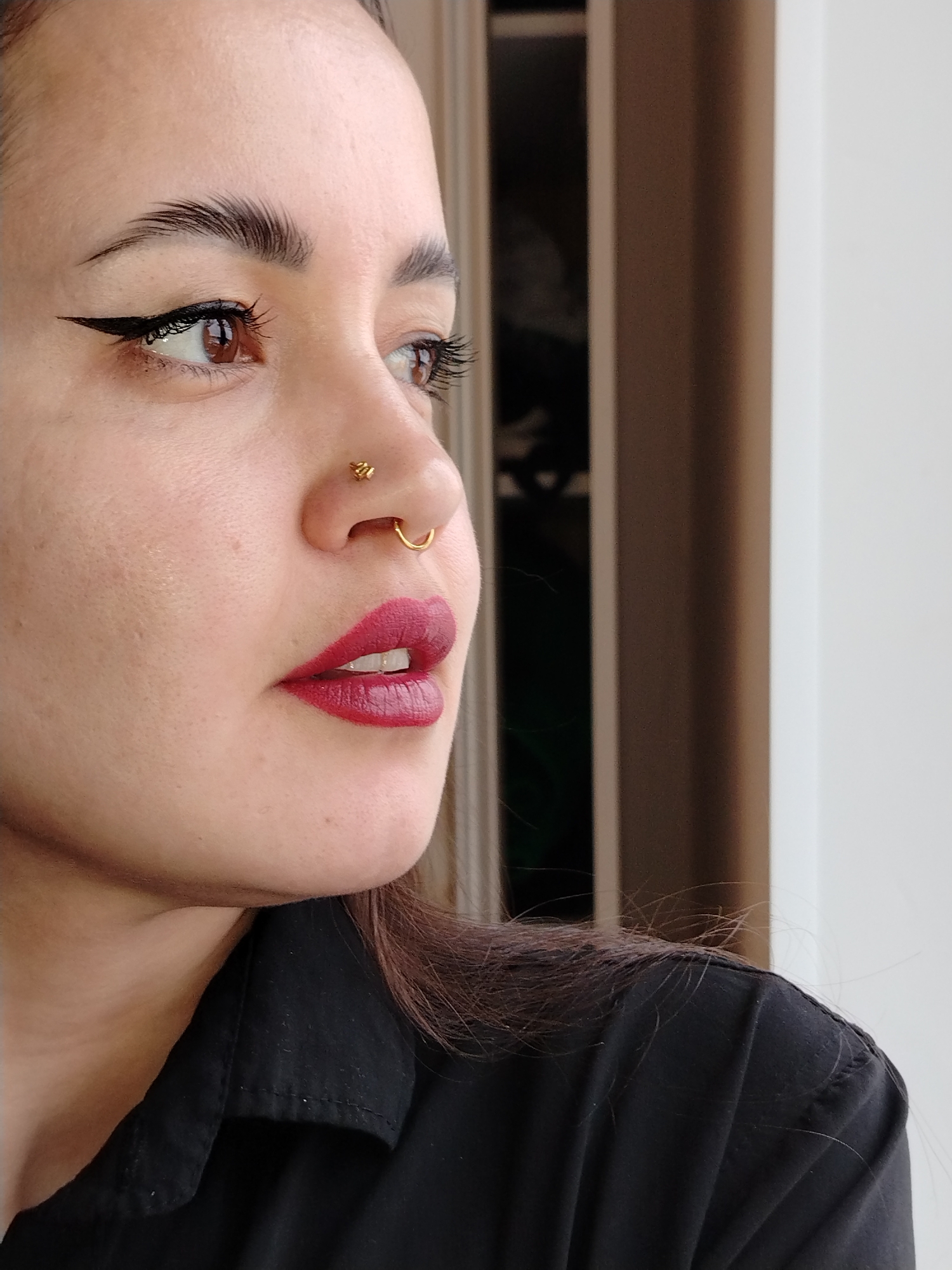 Woman with red lipstick observed gazing toward window
