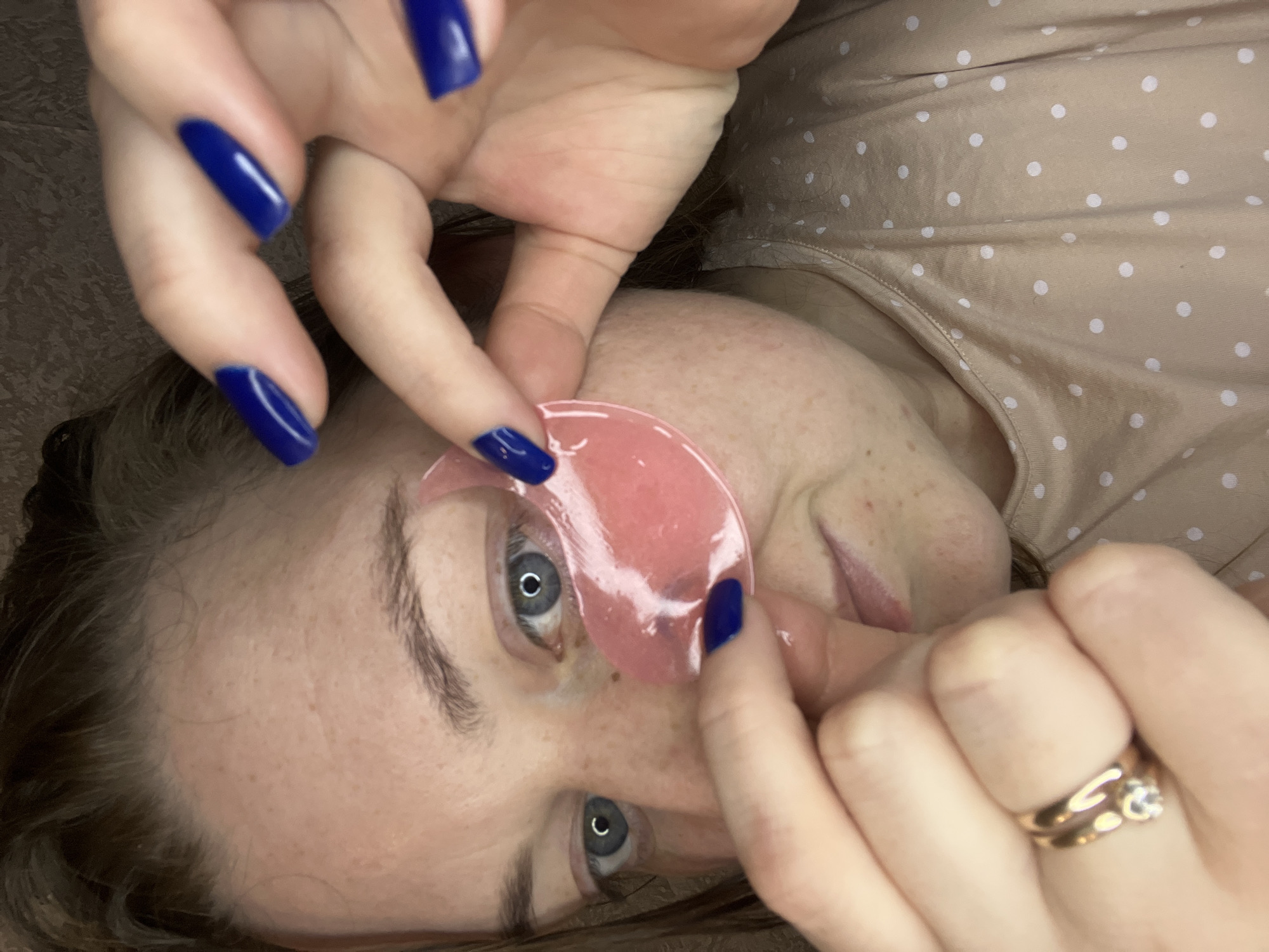 Woman applies beauty patches, rests in fairy-lit room