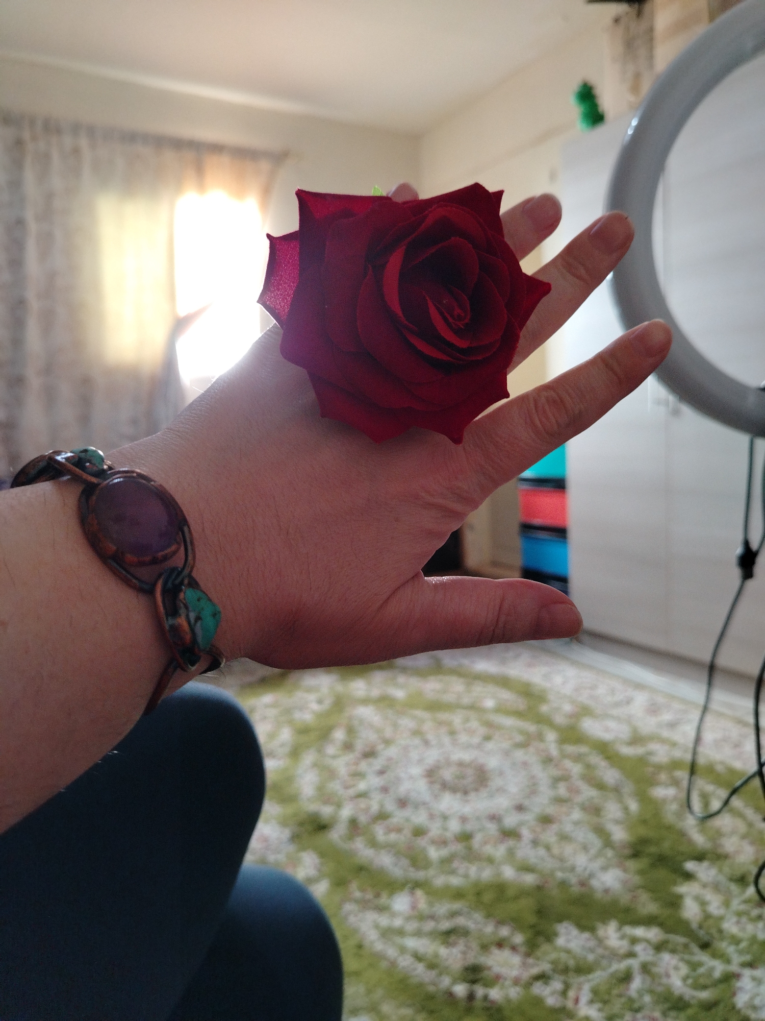 Woman in red rose shirt poses with flowers in UAE
