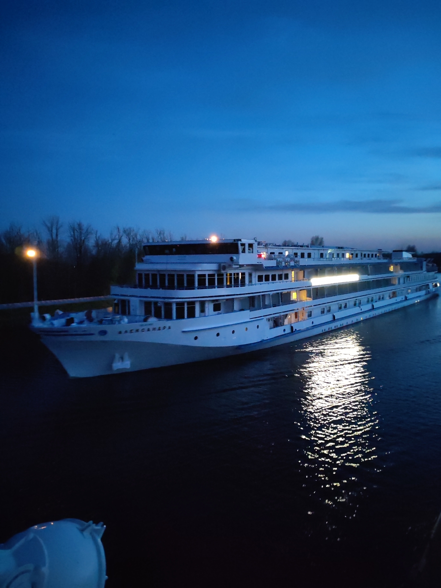 Passenger ship docked at illuminated Dmitrov canal during nighttime