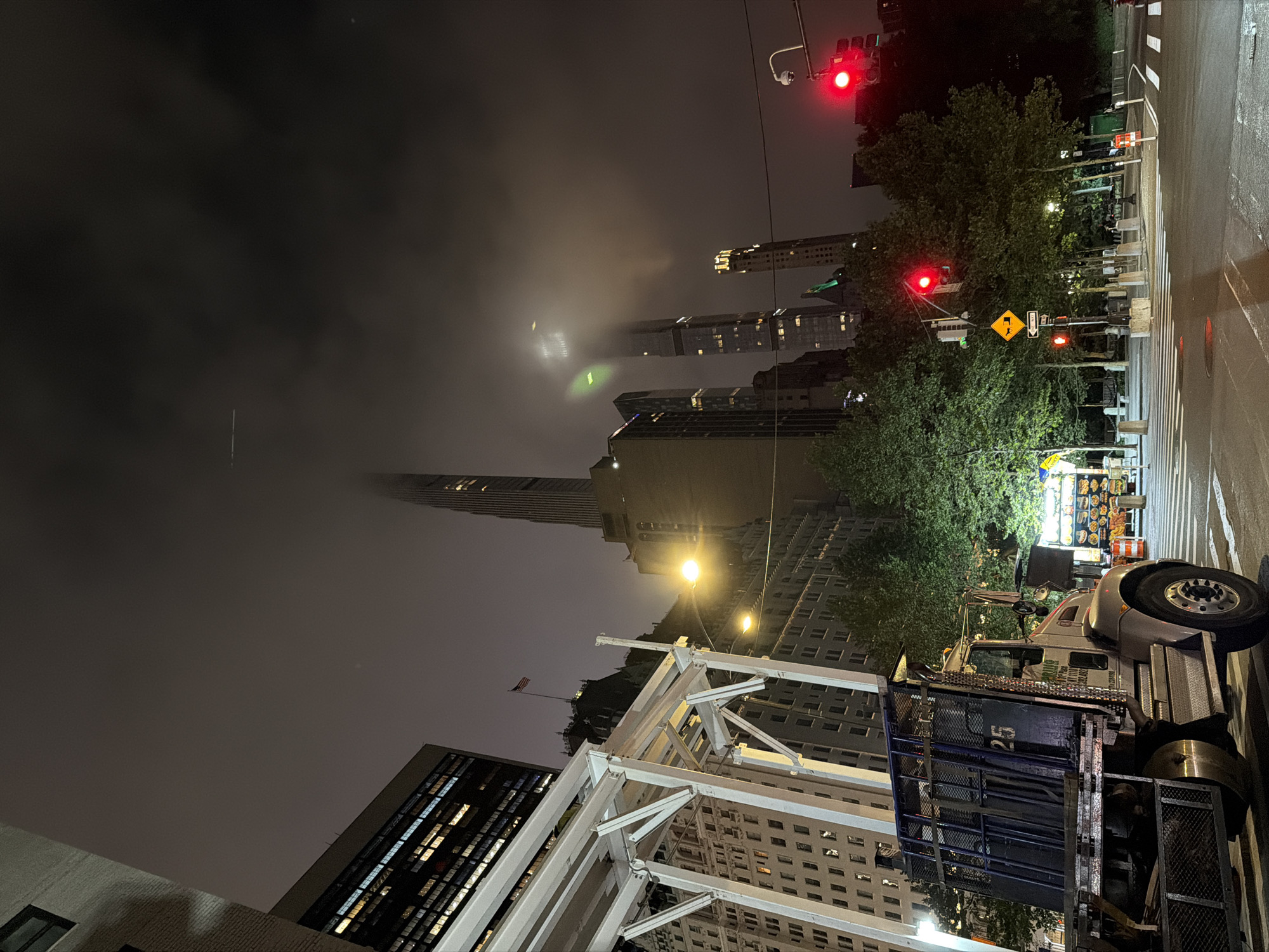 Lumber-loaded flatbed truck parked on NYC street at night