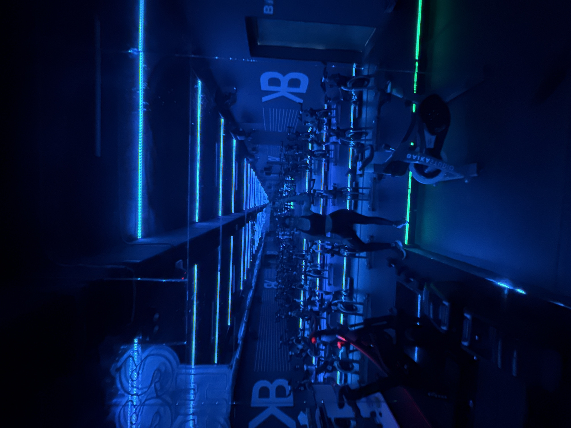 Neon-lit cycling class captured at Puebla fitness studio