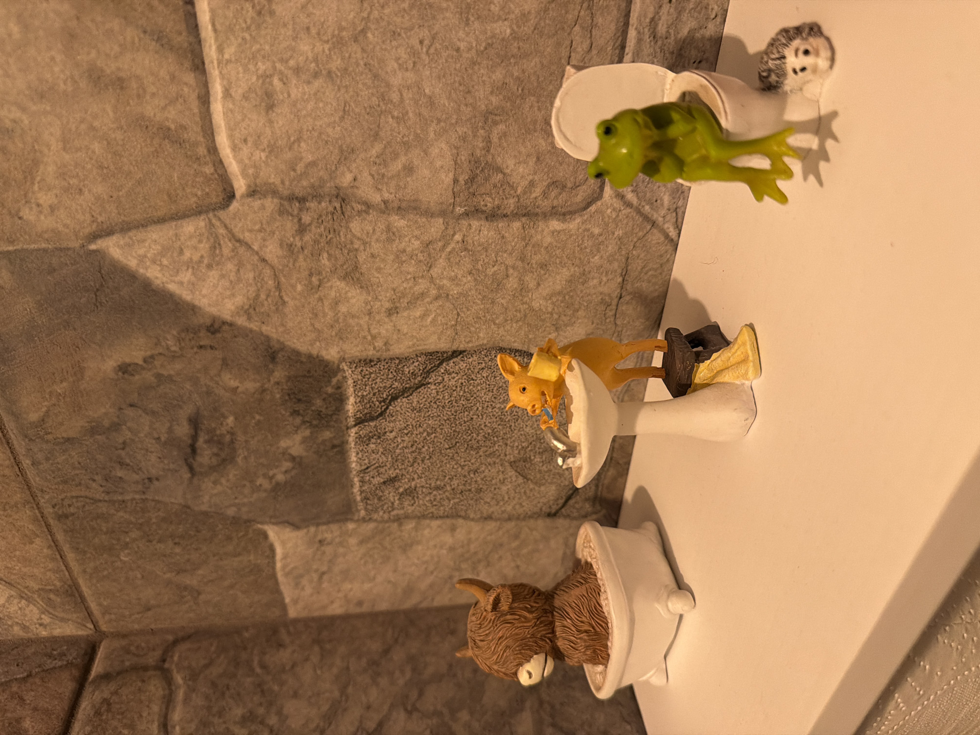 Animal figurines displayed on miniature bathroom fixtures in Cuernavaca