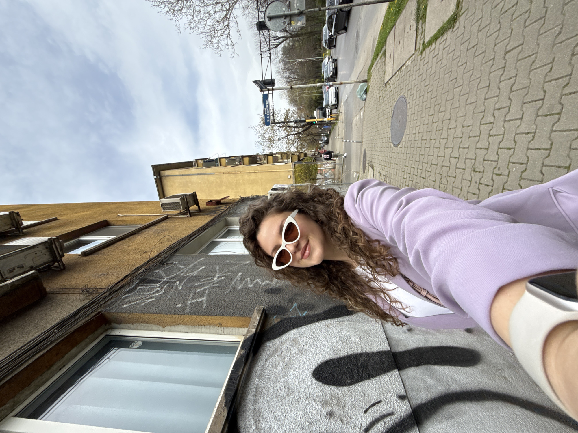 Woman takes street selfies in Sofia on overcast afternoon