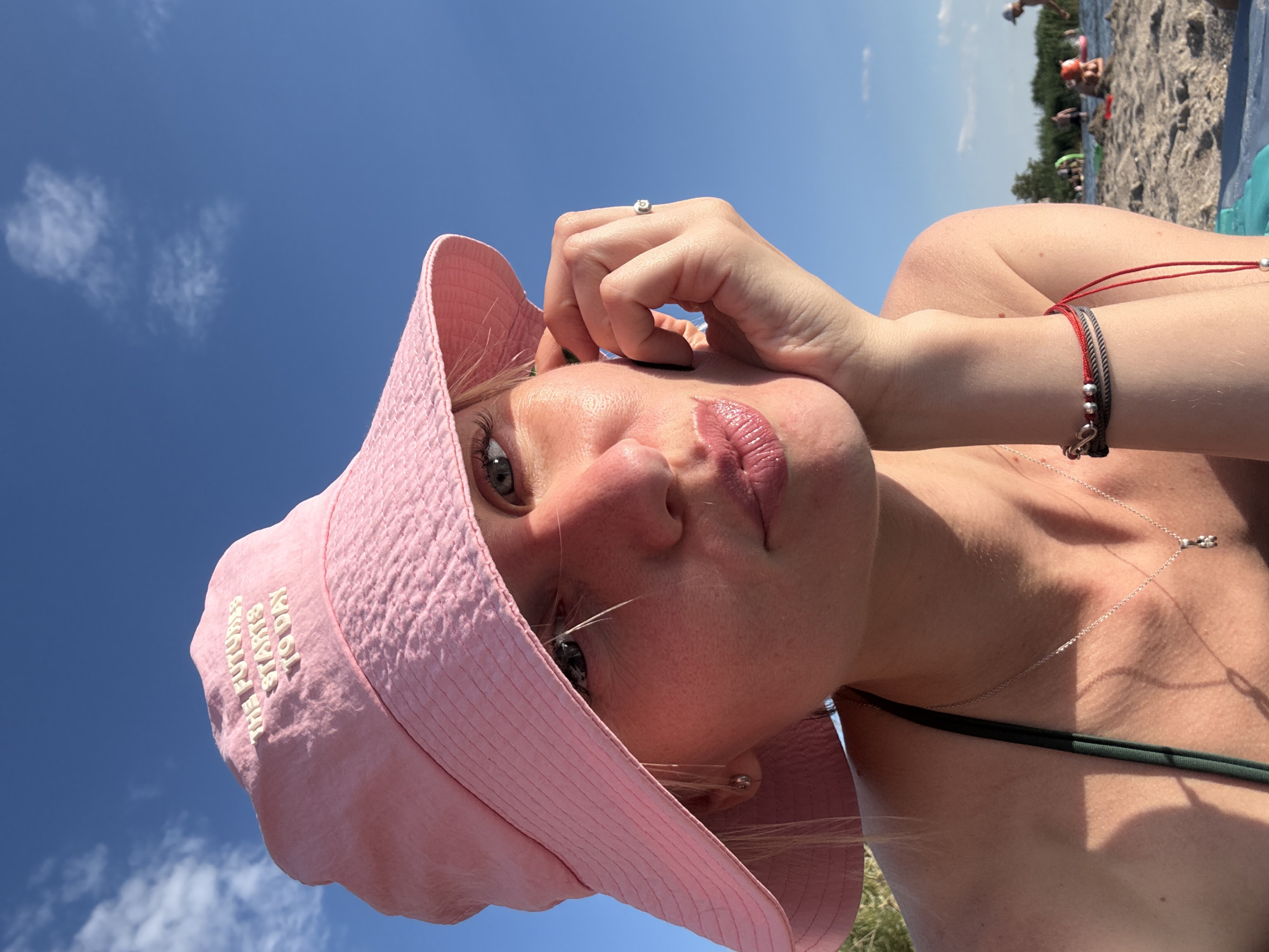 Selfie in a pink bucket hat and green bikini top