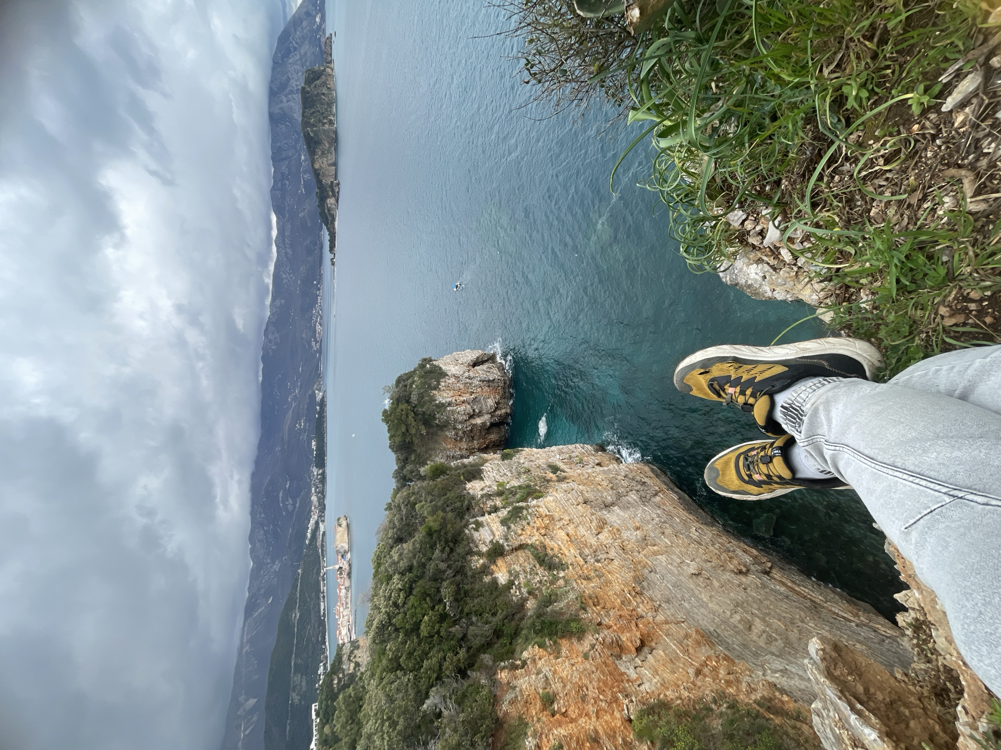 Tourist documents scenic clifftop views along Budva coastline