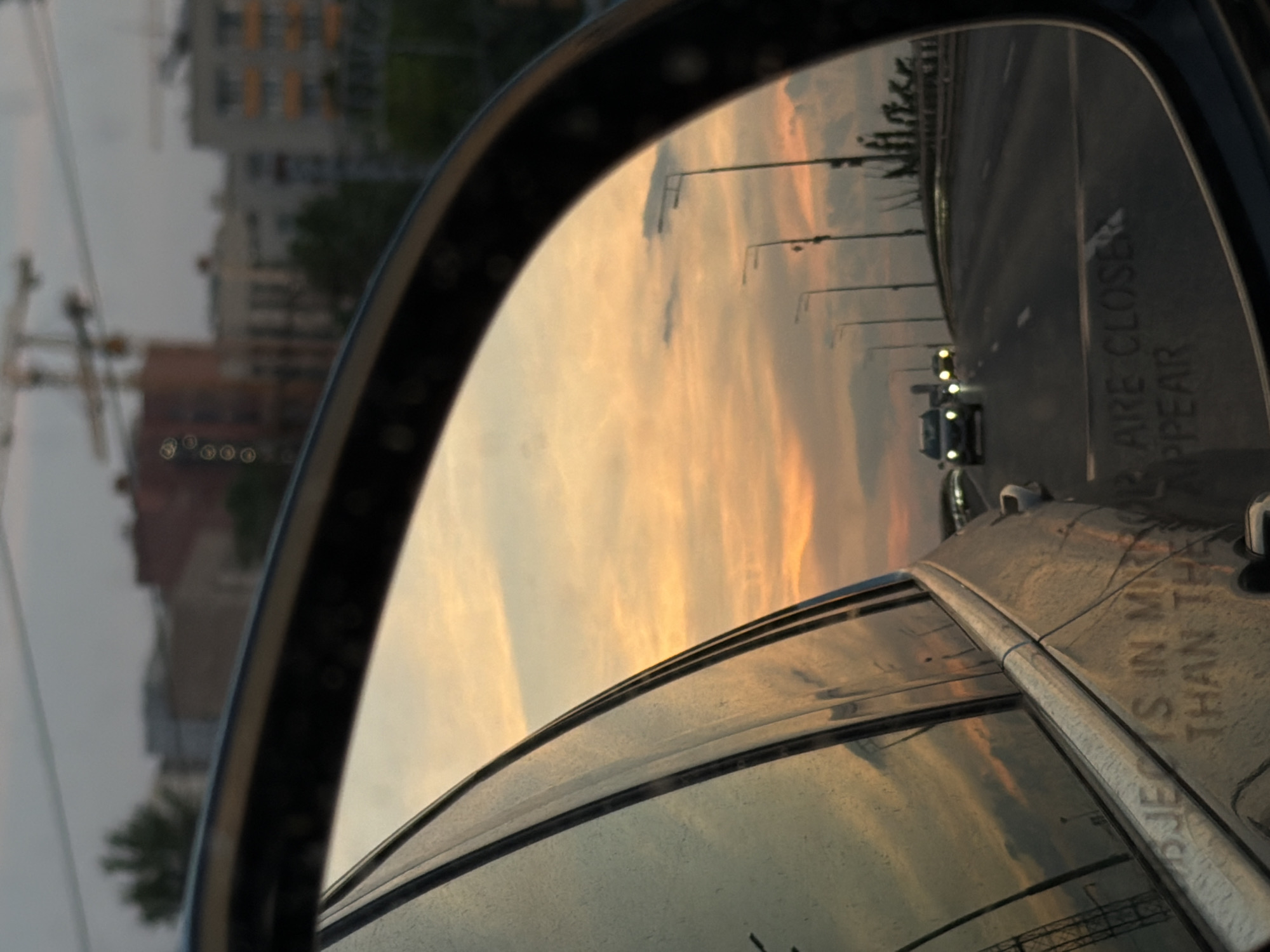 Twilight street scene captured in car mirror, Moscow