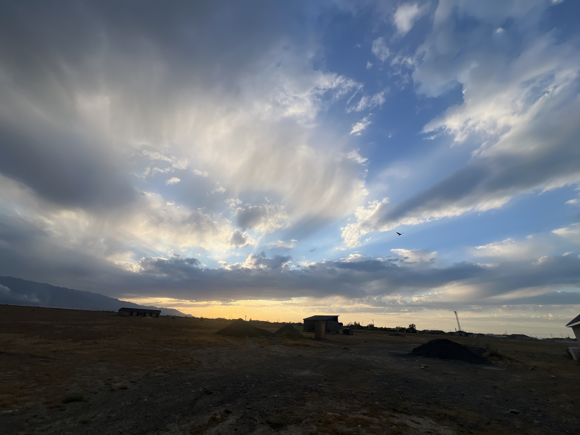Smoke rises over Kazakhstan steppe at golden hour