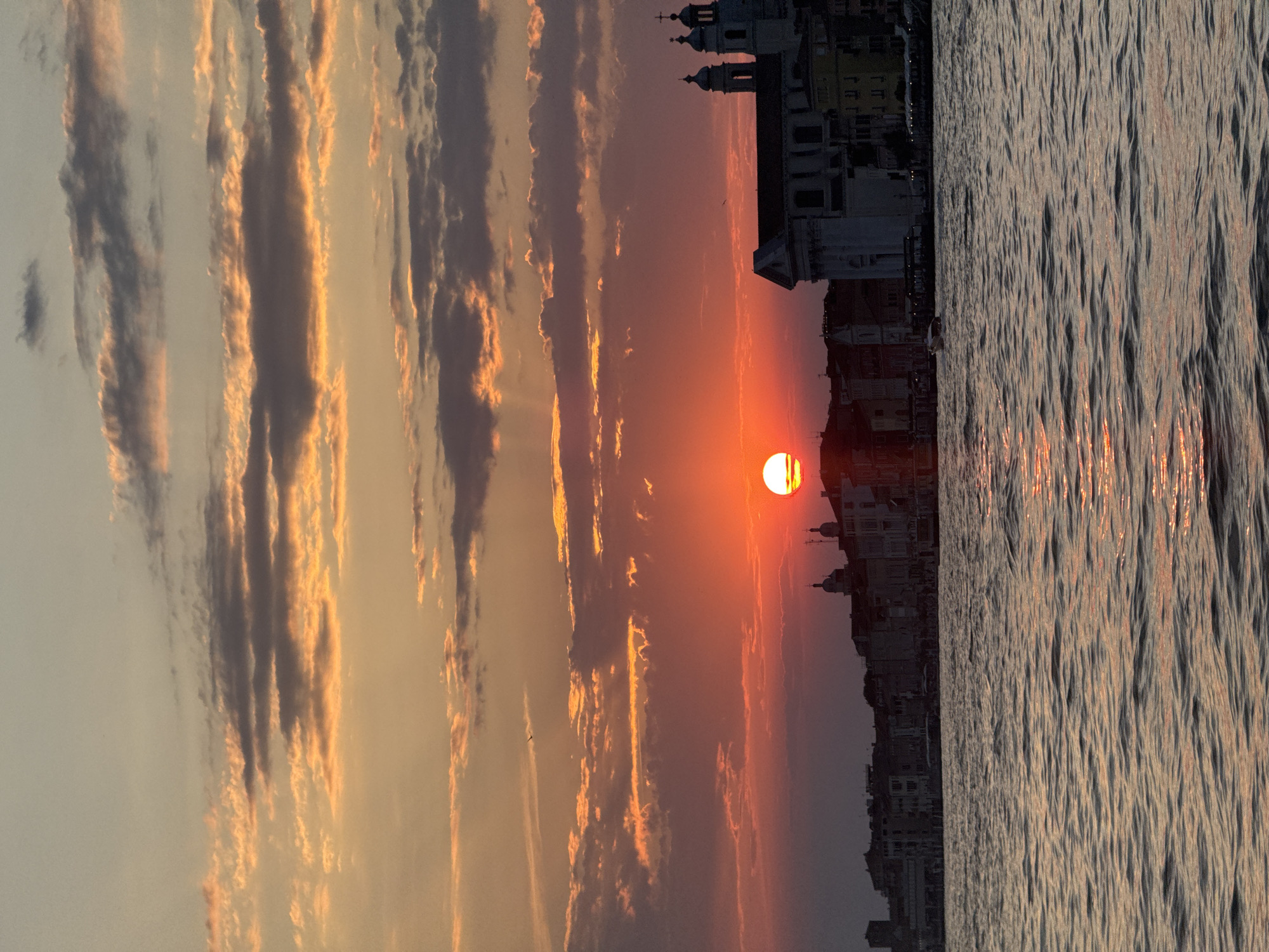 Venice at golden hour, canals and sailboats at dusk