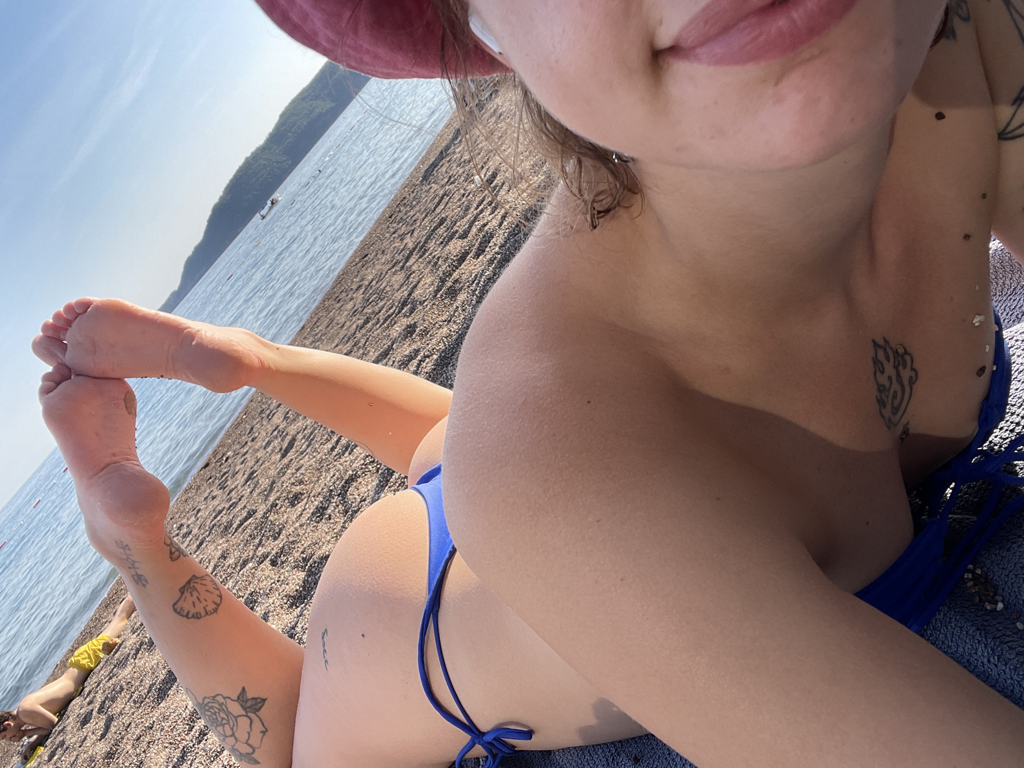Beachgoer takes selfies on towel in Rafailovići, Montenegro