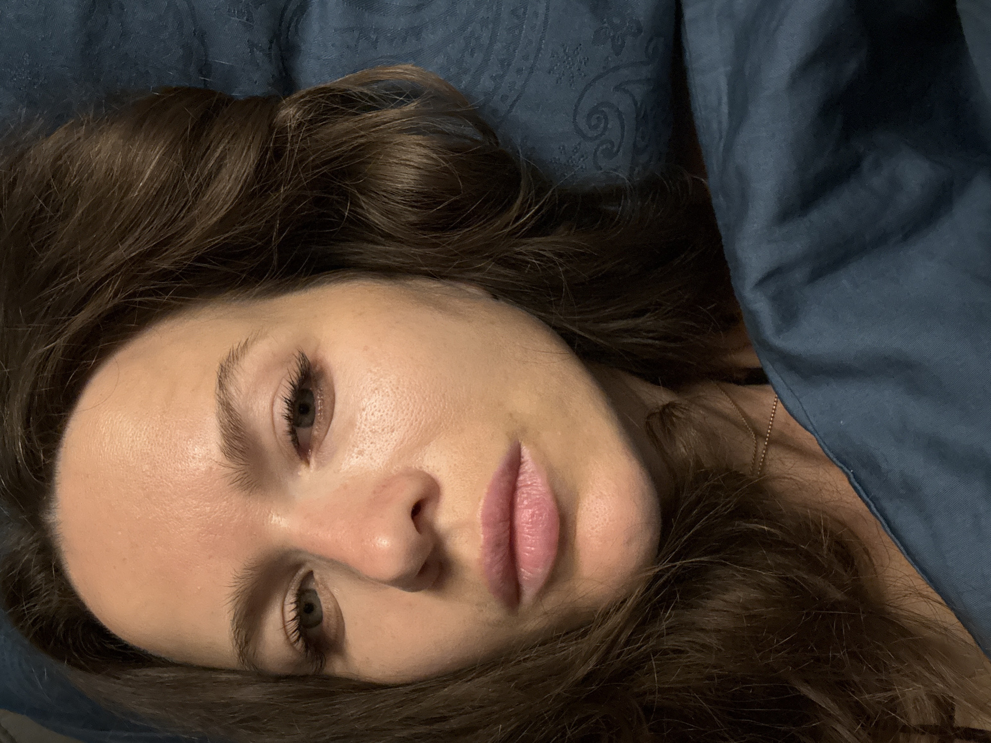 Portrait photograph captured of woman on blue bedding in Khimki