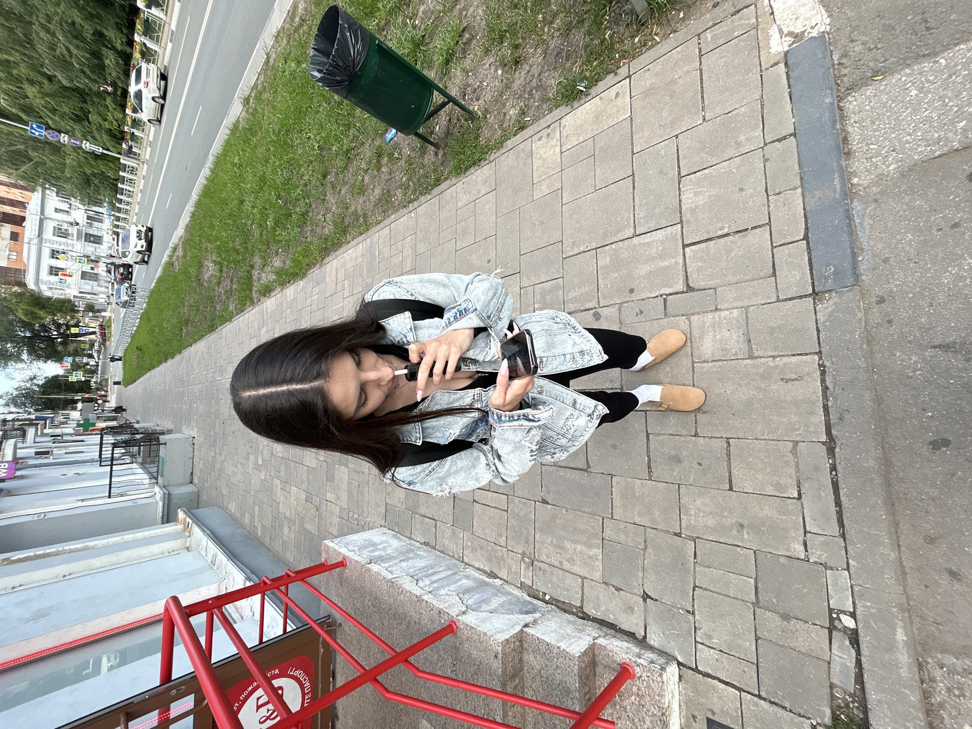 Vaping and scrolling on a Novokuybyshevsk sidewalk