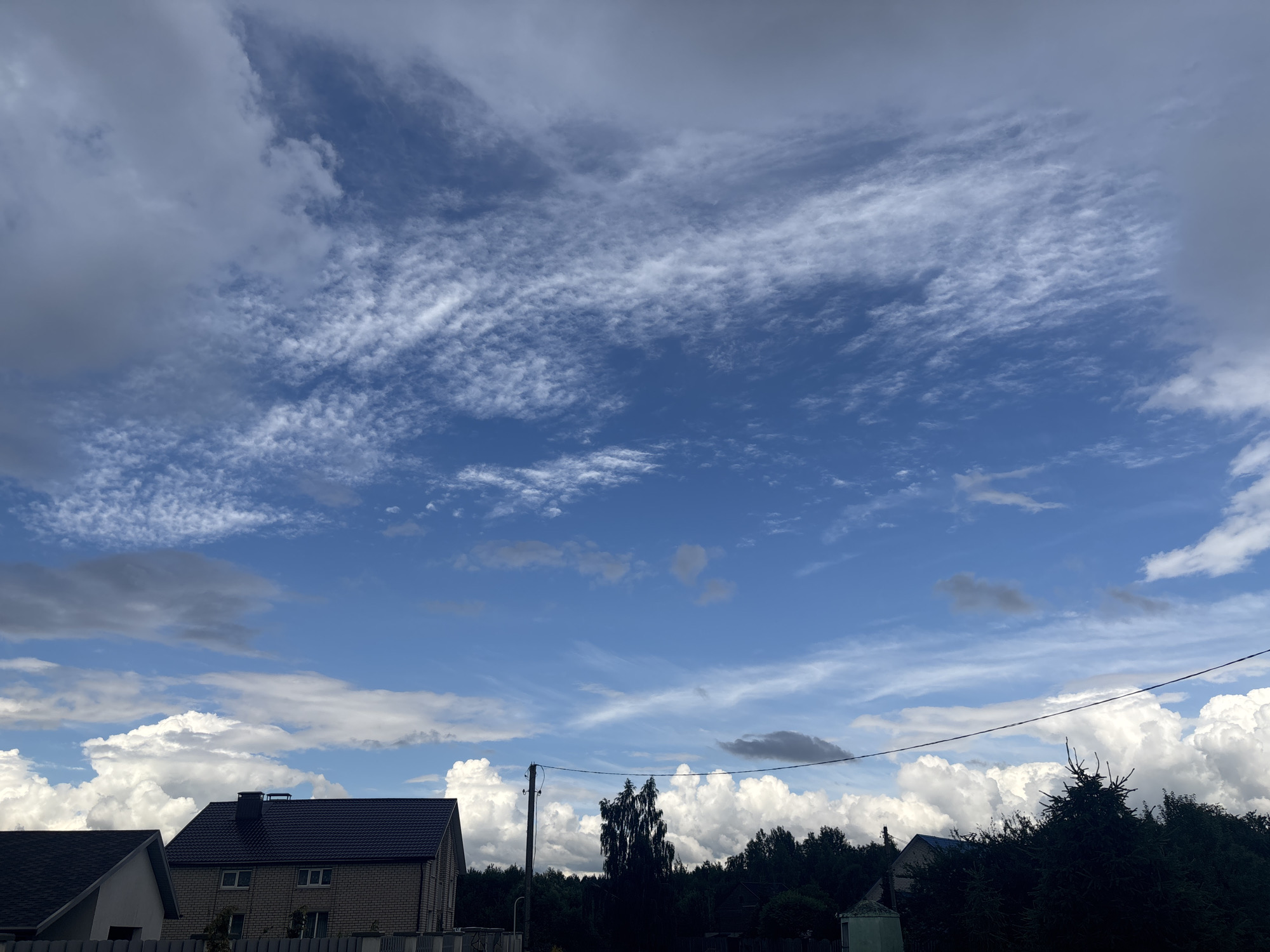 Quiet rural village street under dramatic summer skies, Belarus