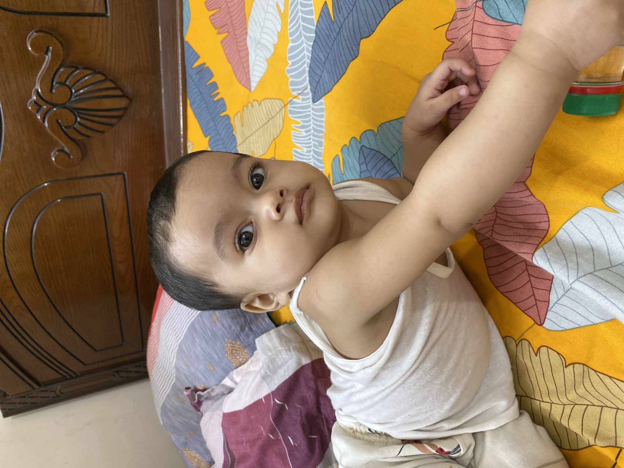 Baby photographed in multiple poses during indoor session in Dhaka