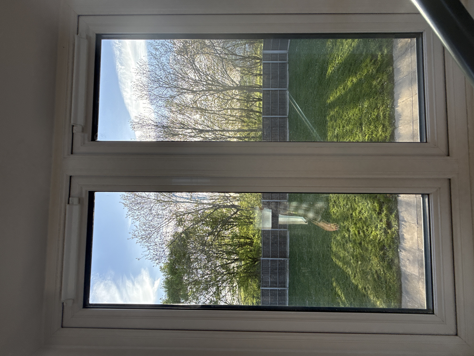 Window view captures bare trees against cloudy sky in Great Yarmouth