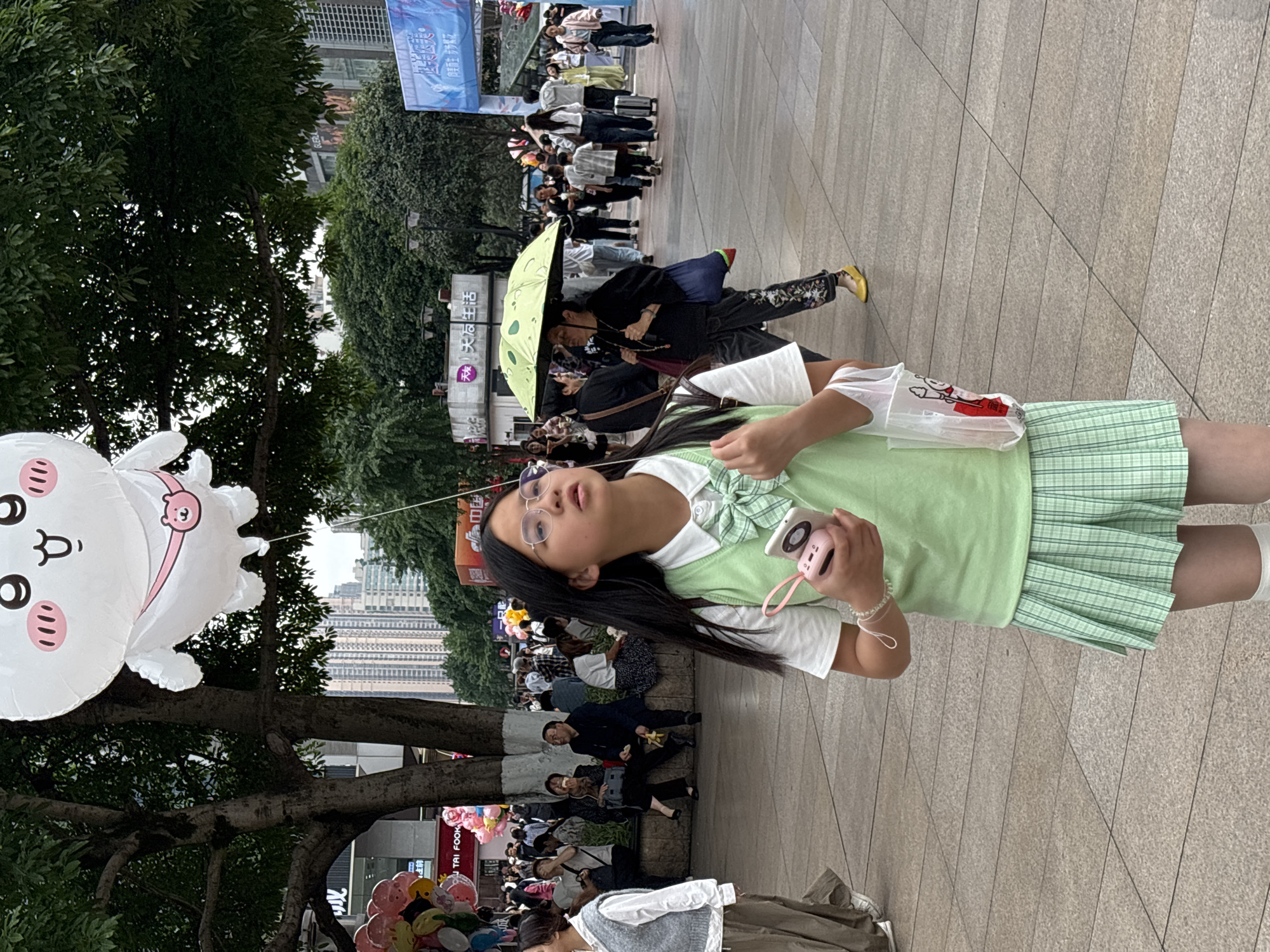 Student with pink camera photographed in Chongqing public space