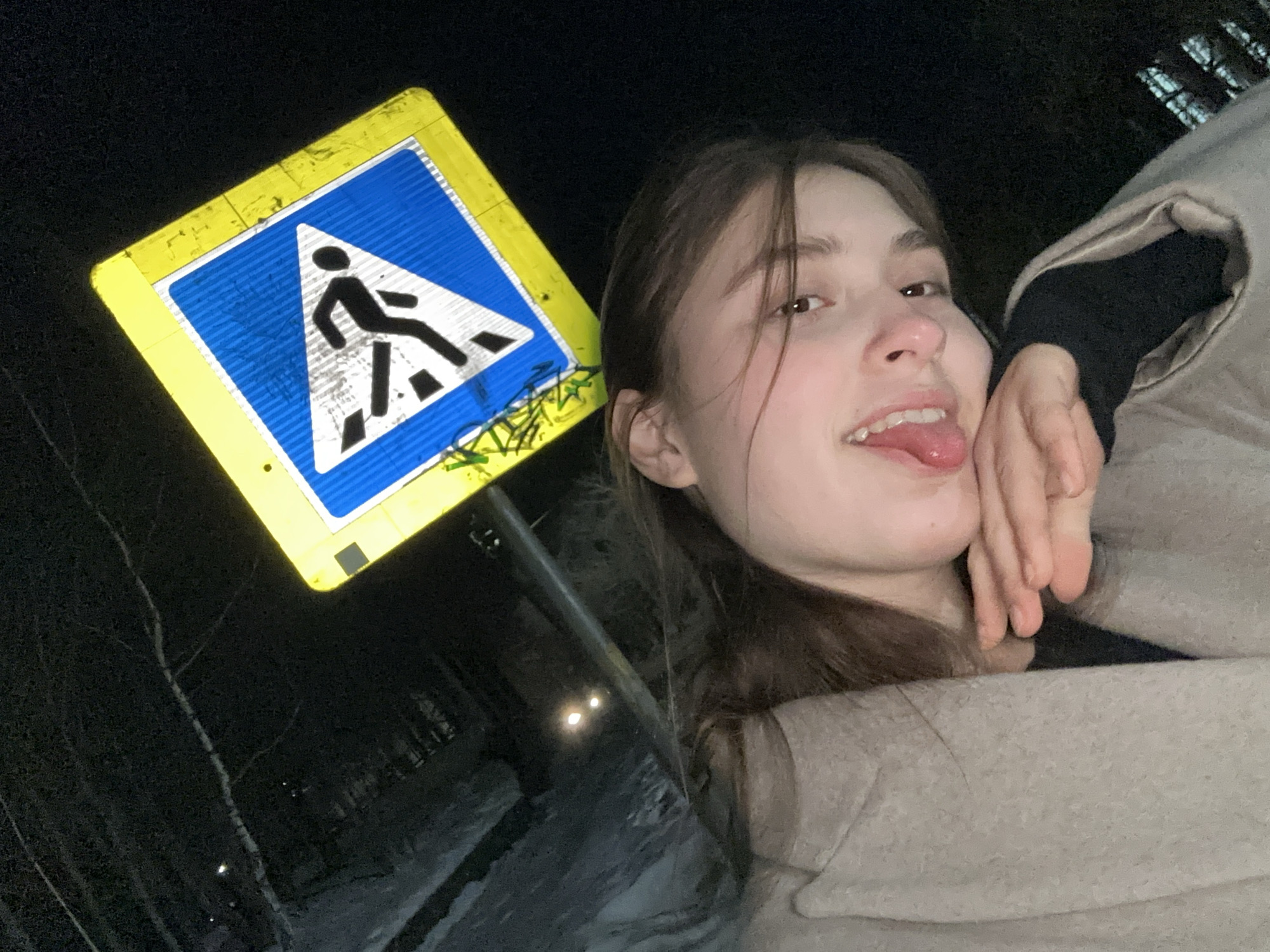 Woman poses with pedestrian crossing sign in Sarapul