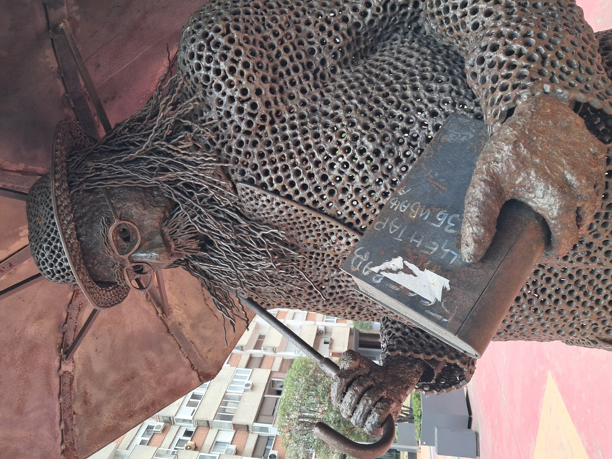 Belgrade chainmail sculpture of a figure with umbrella and book