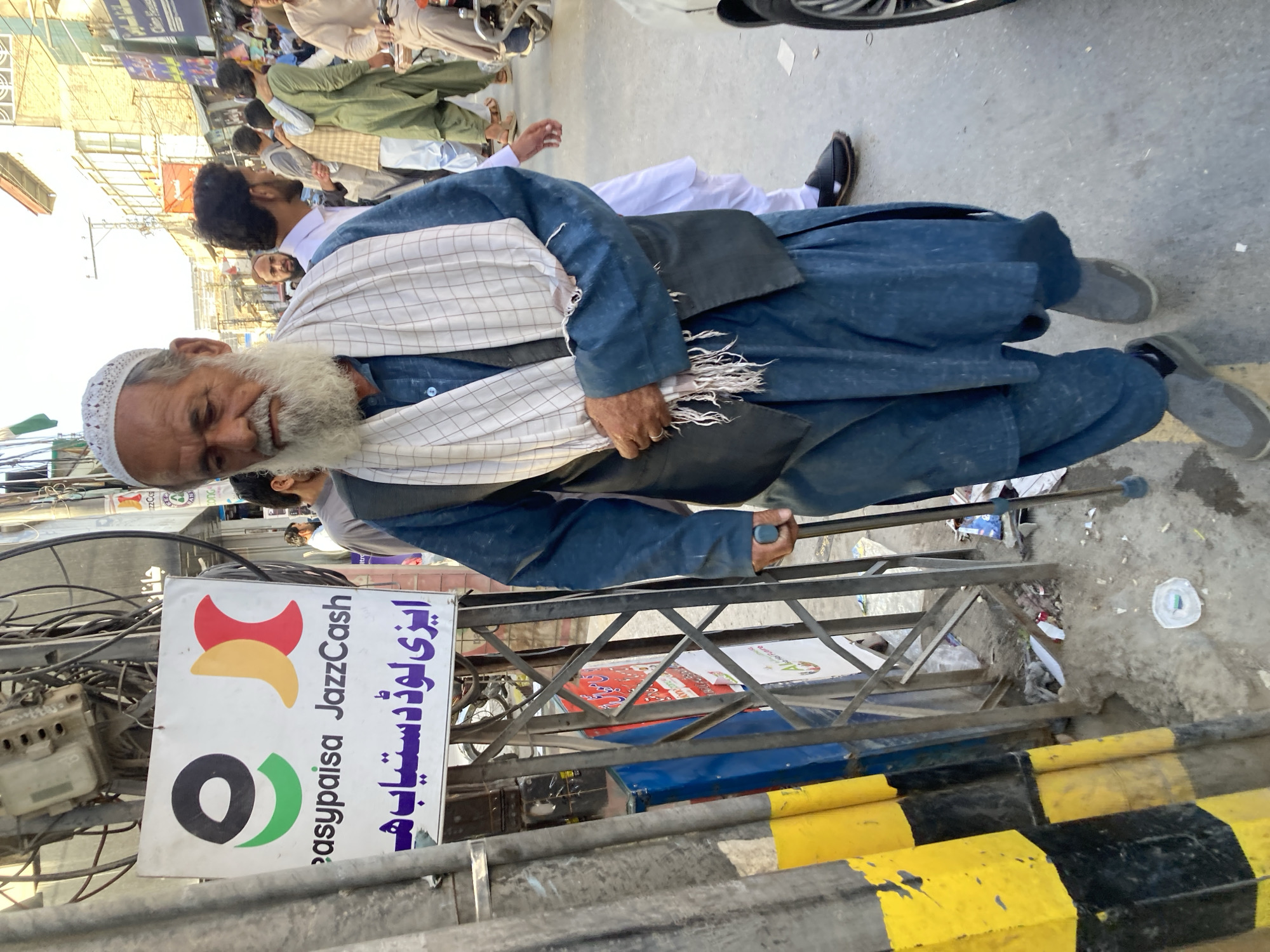 Elderly man walks street in traditional dress, Quetta