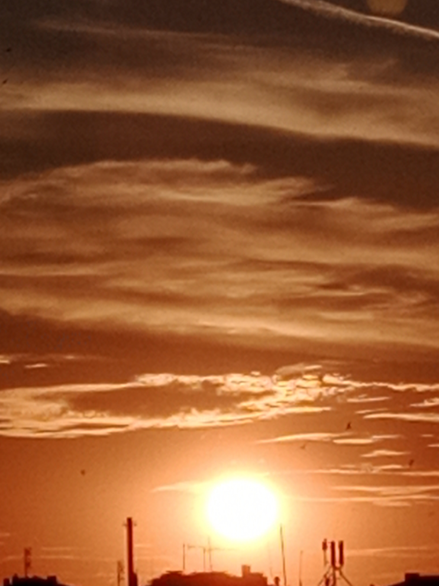 Bydgoszcz skyline silhouetted against a vivid summer sunset
