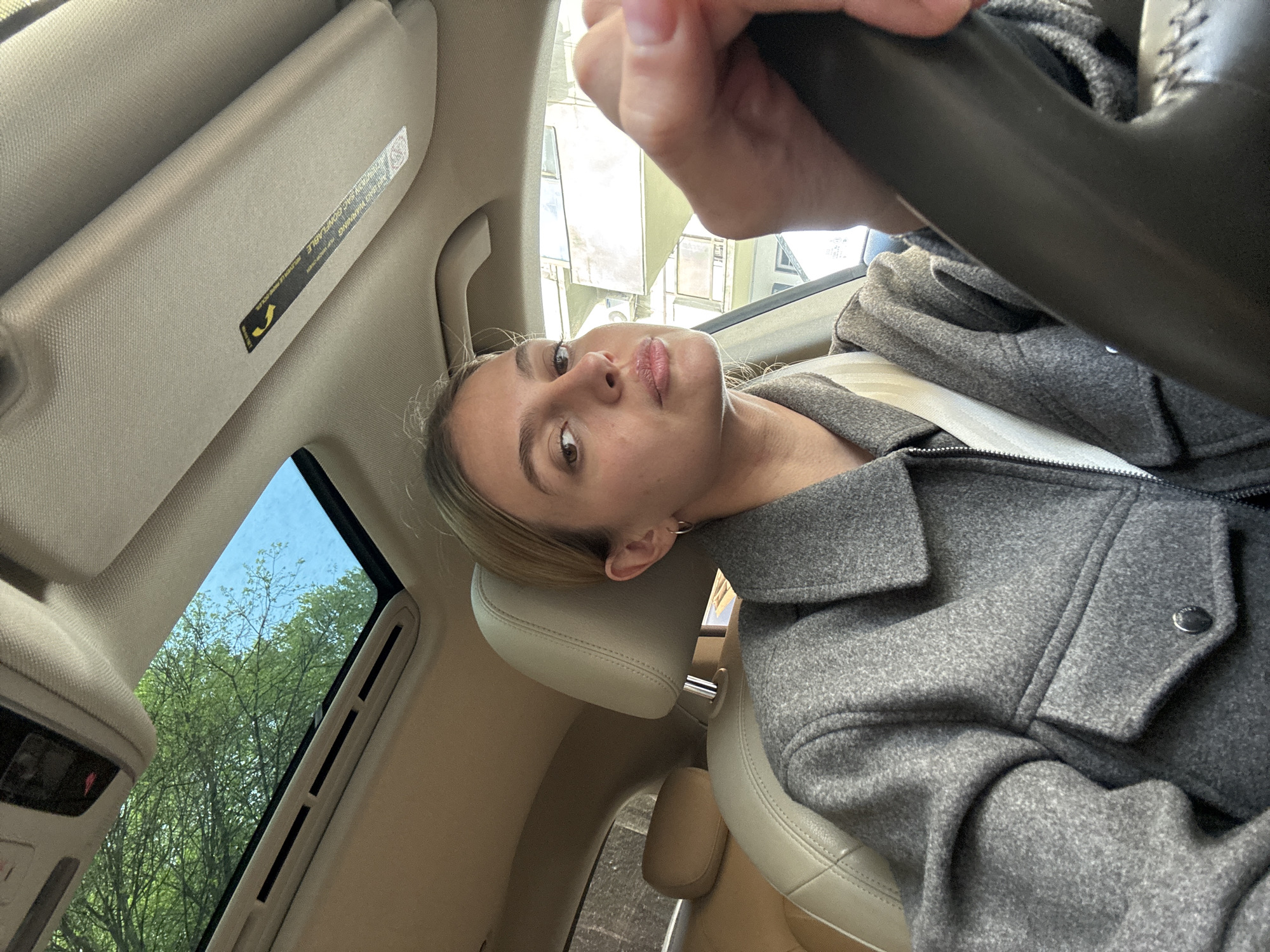 Woman sits in car driver's seat in Tbilisi