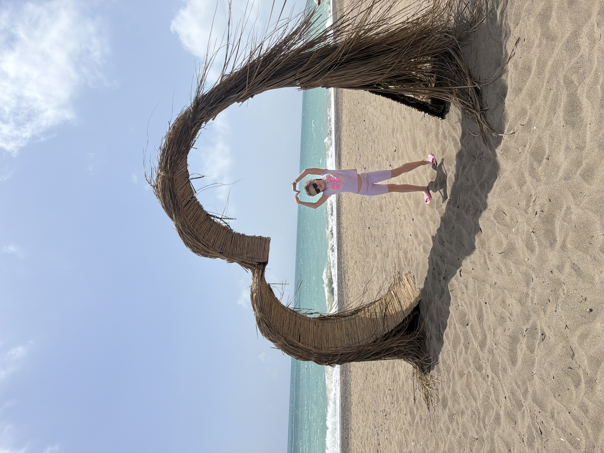 Girl poses in heart structure on Turkish beach