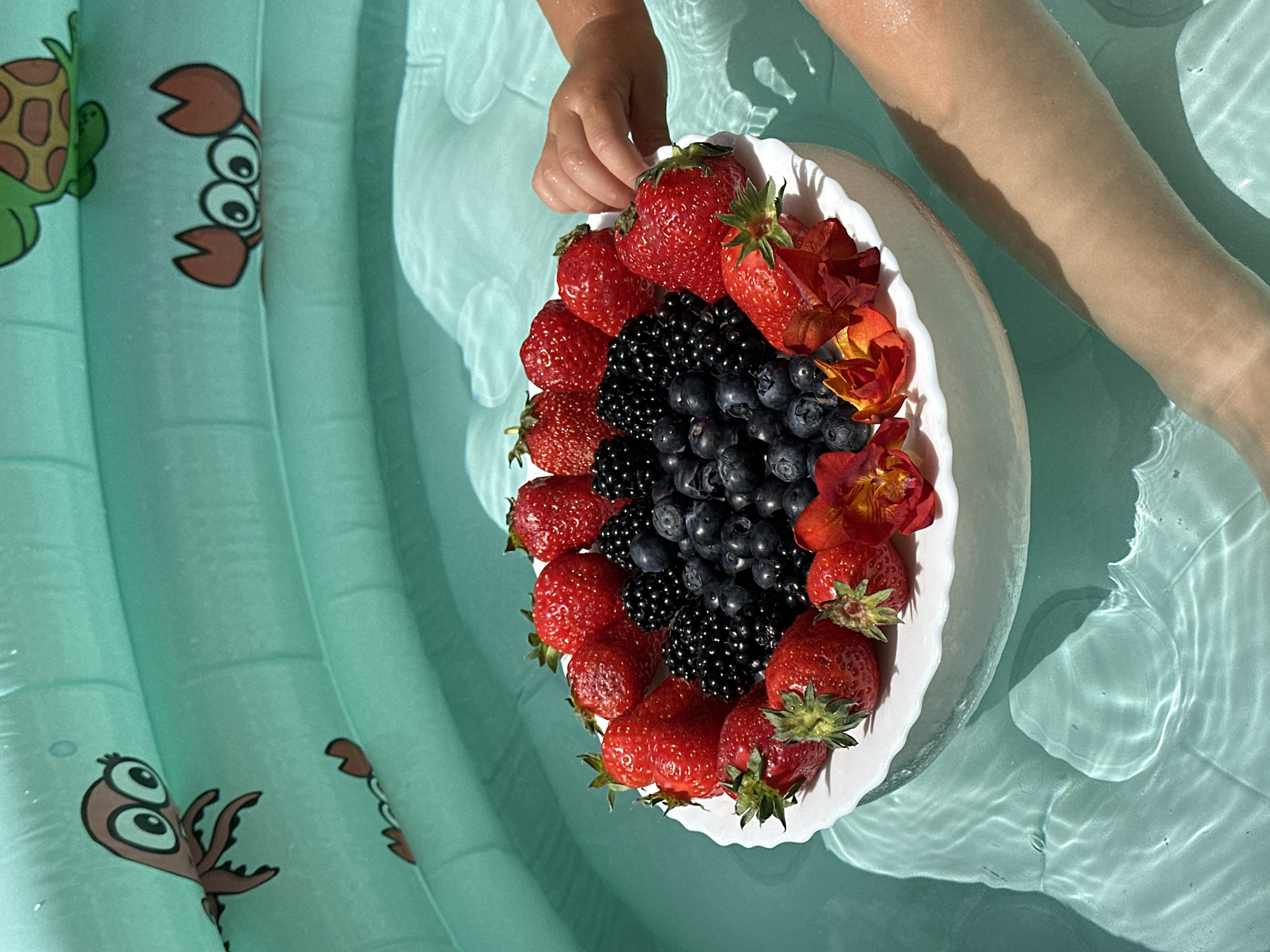 Toddler enjoys pool time with fresh berries in Wisła