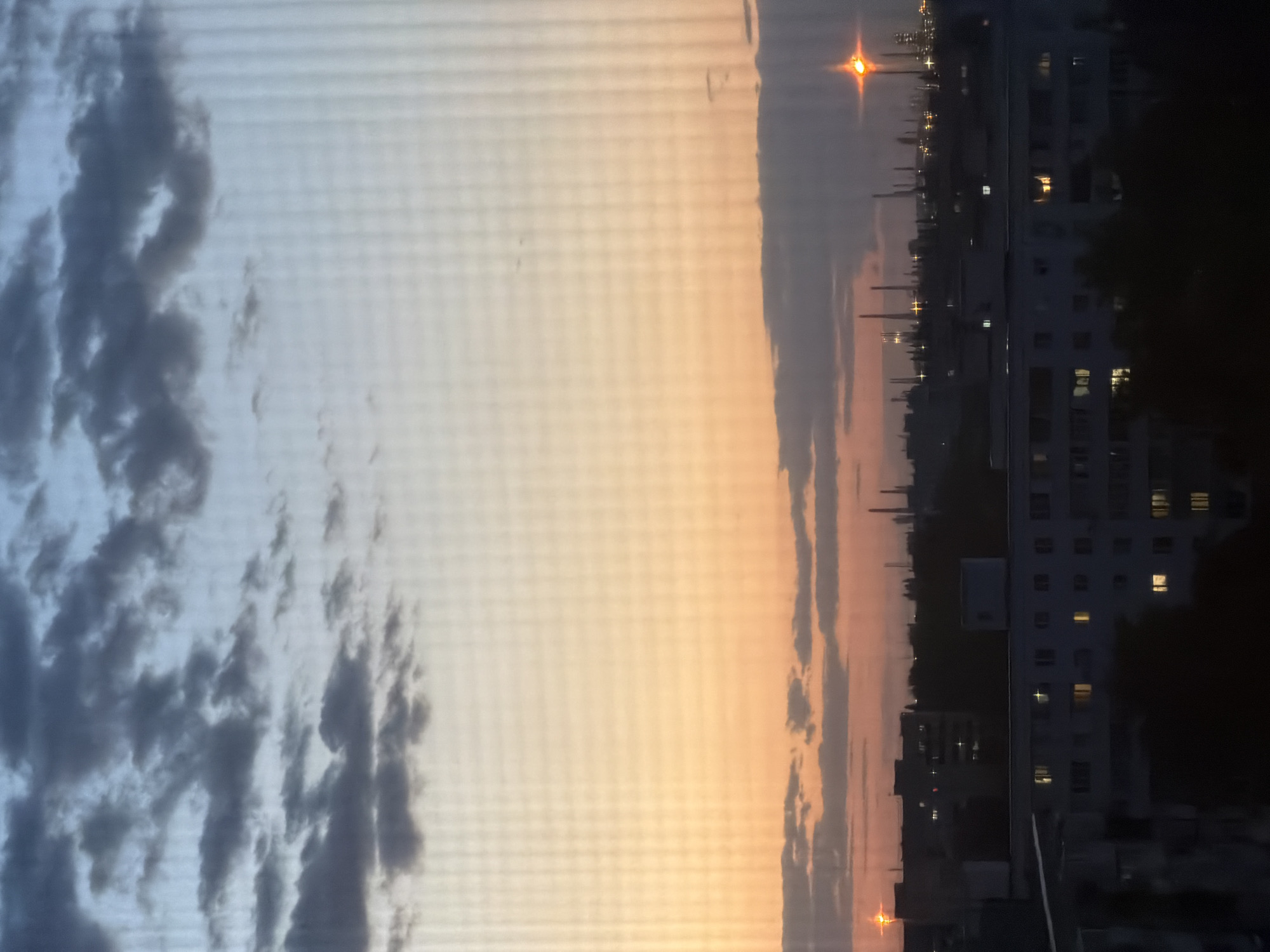 Dusk cityscape transition documented through window screen May 24