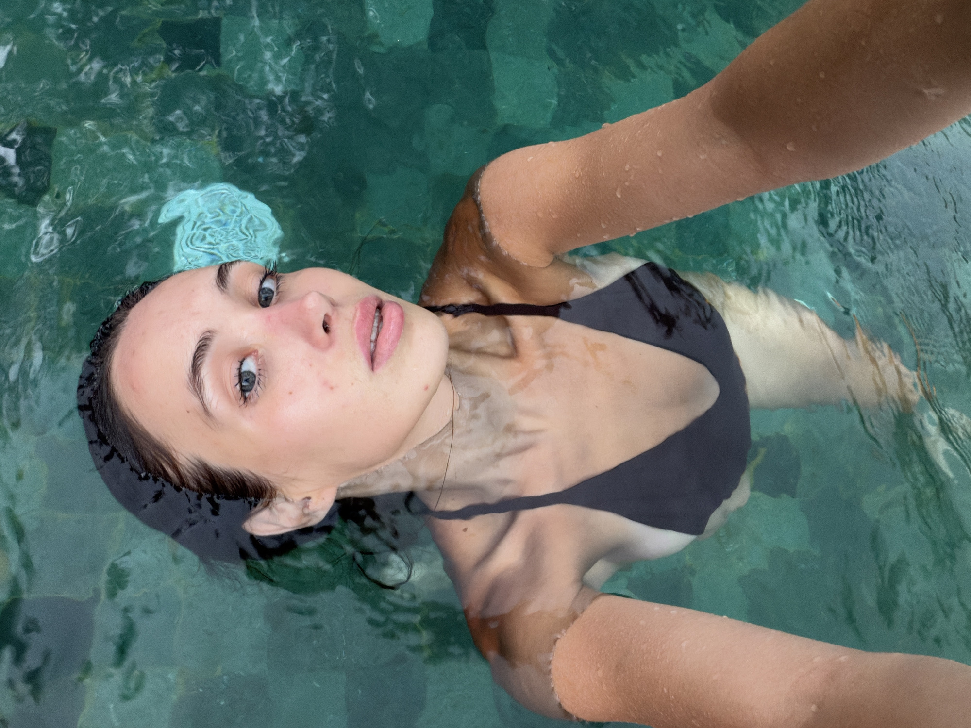 Woman floats peacefully in pool in Ubud, Indonesia