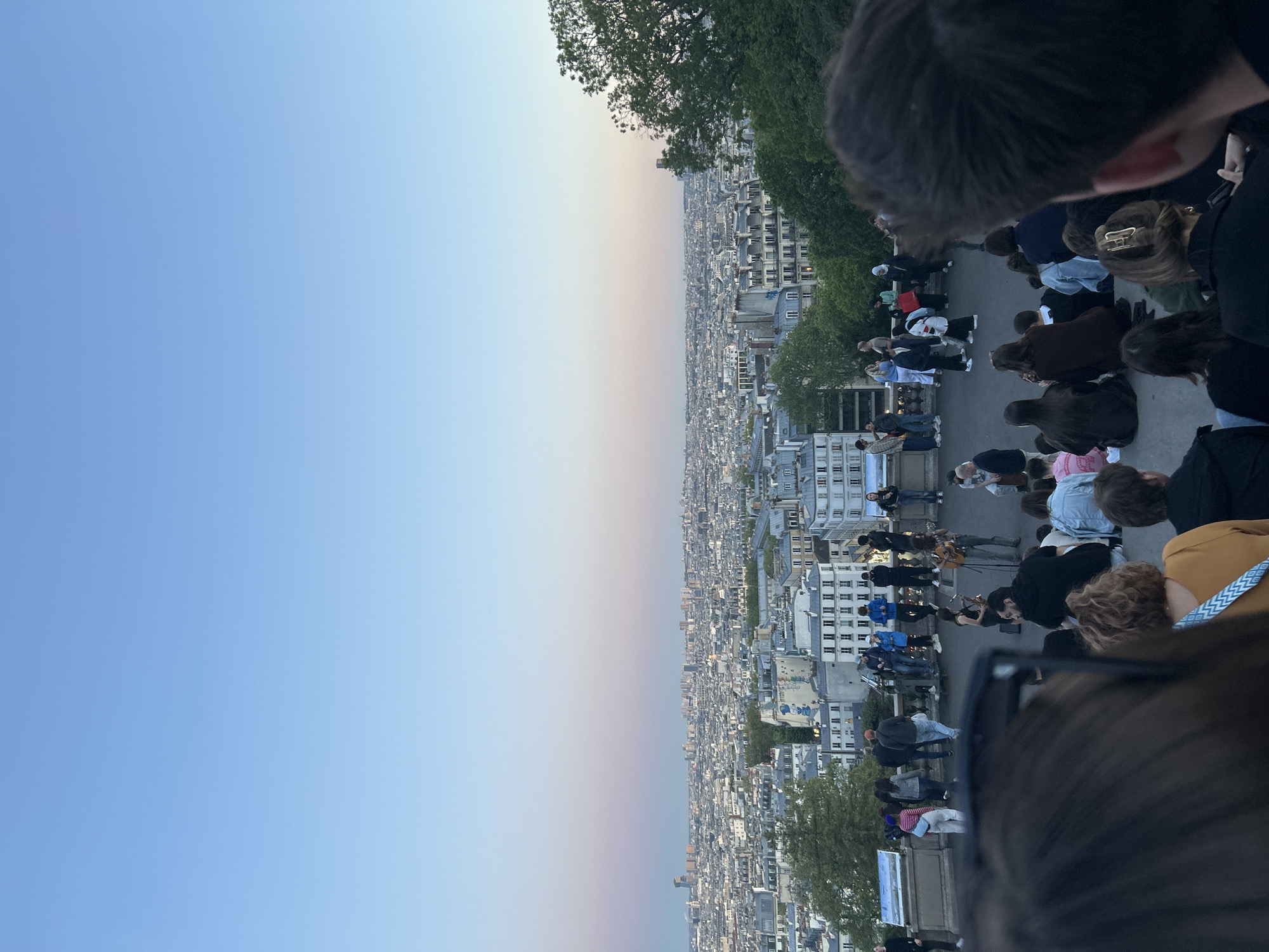 Crowd gathers for music performance overlooking Paris at dusk