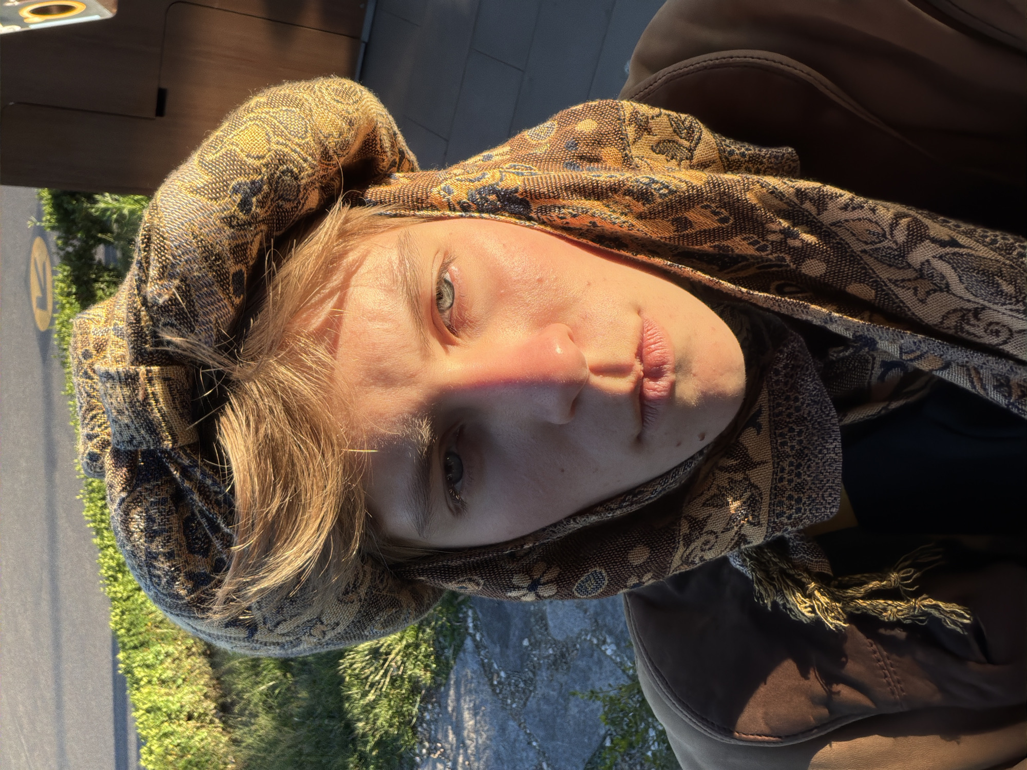 Portrait captured of person in brown headscarf at coordinates 666