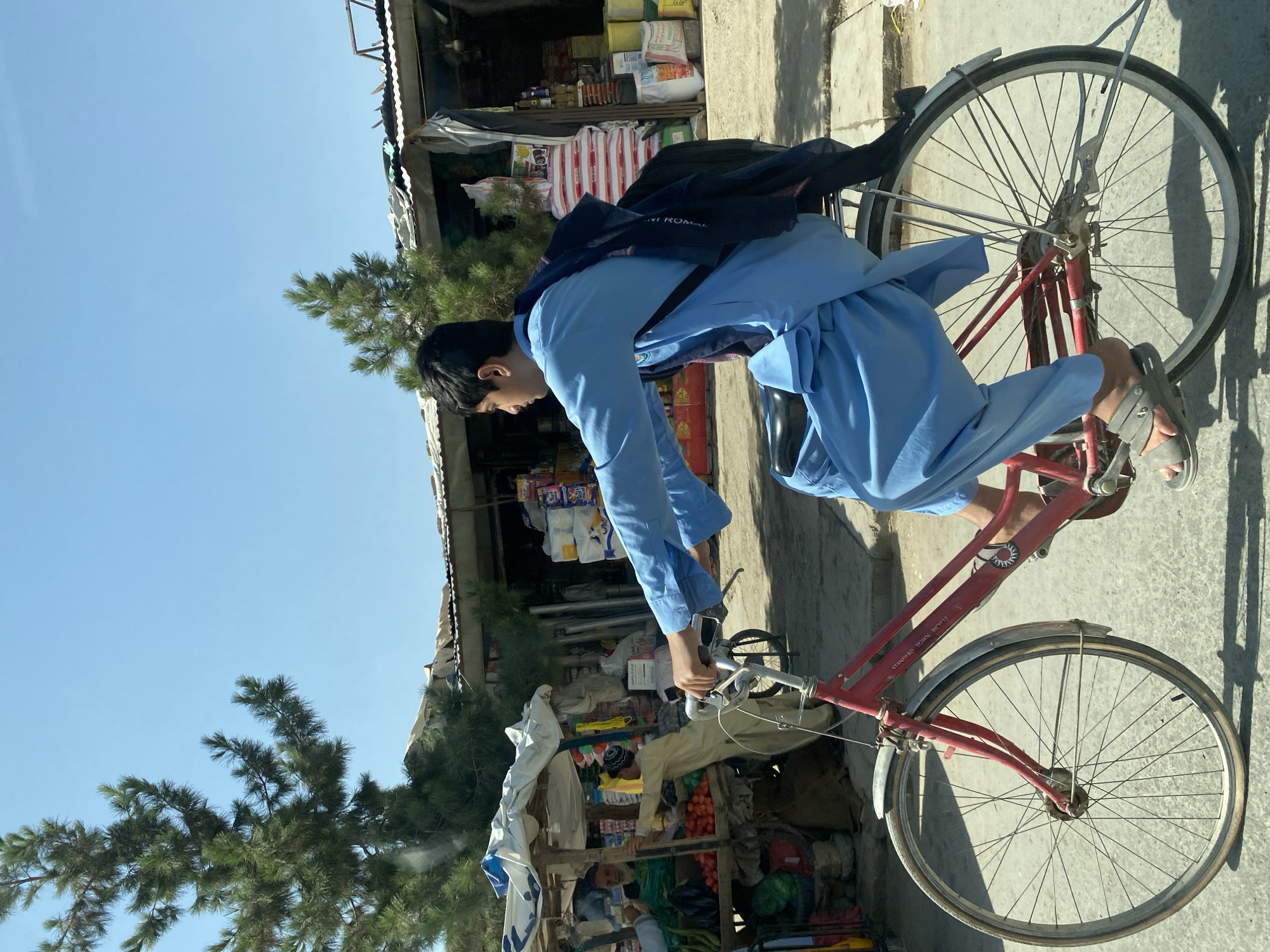 Cyclists navigate a busy Kandahar street market