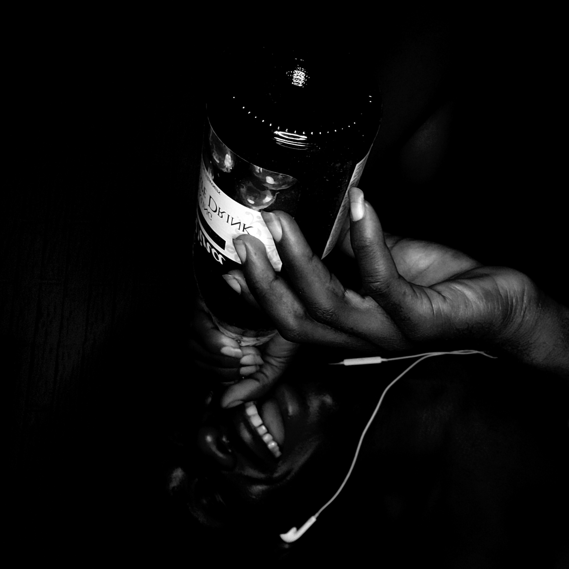 Person with headphones photographed holding drinks in Narayi, Nigeria