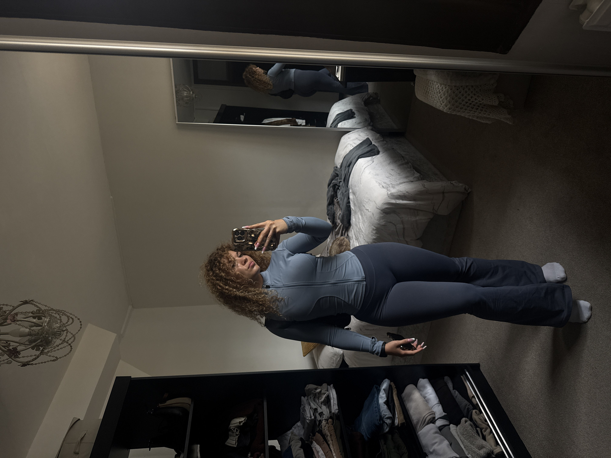 Woman takes bedroom mirror selfies in London athletic wear