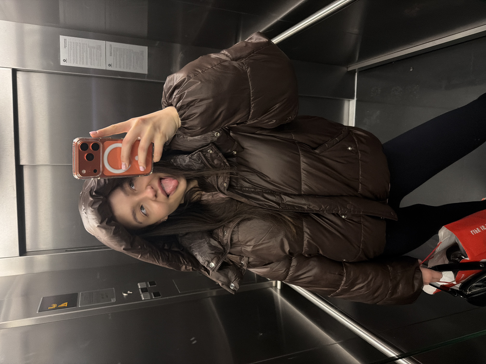 Person takes playful tongue-out selfie in Sofia elevator