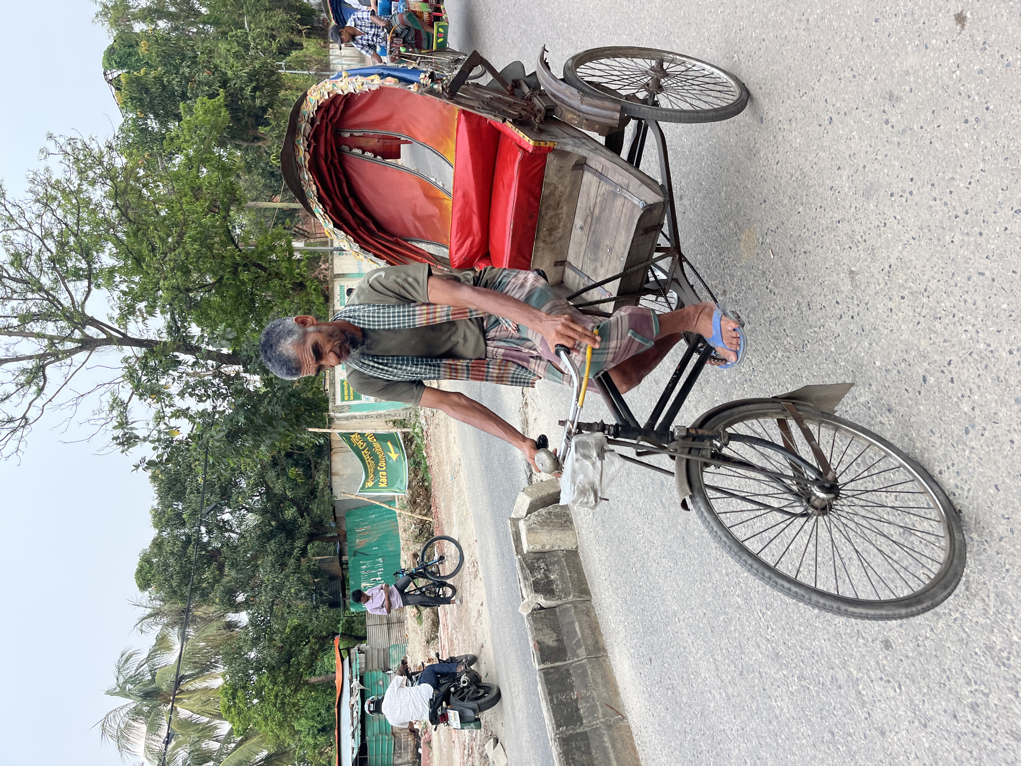 Morning street commerce bustles across Dhaka with vendors and rickshaws