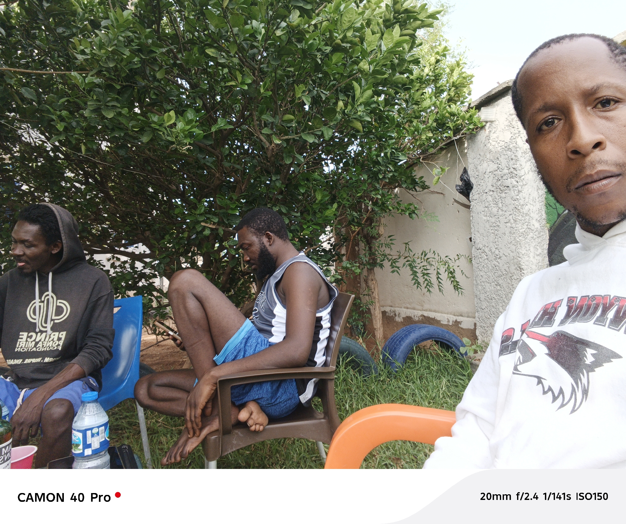 Three men gather outdoors in casual morning scene