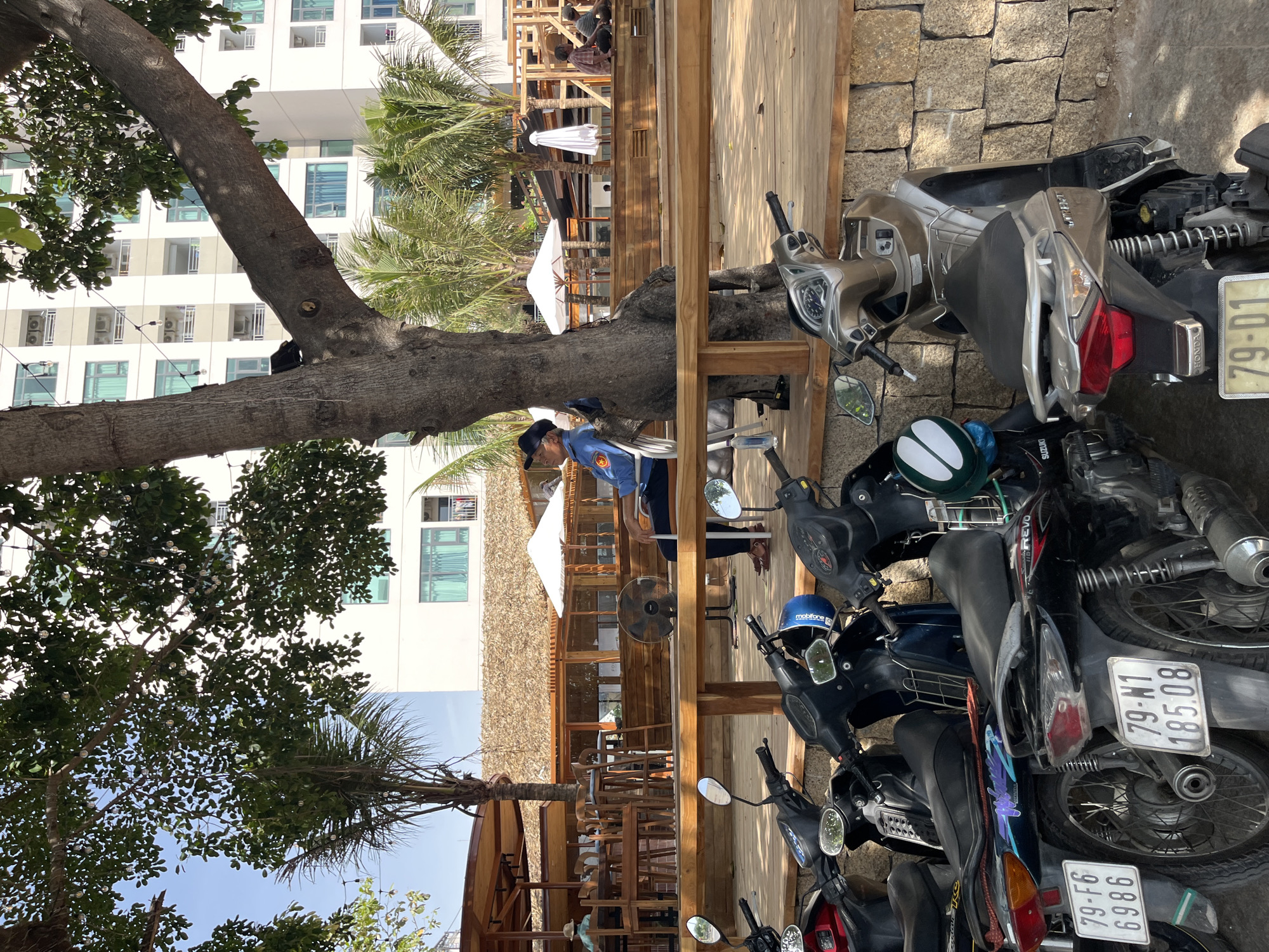 Motorbikes parked outside thatched-roof cafe in Nha Trang