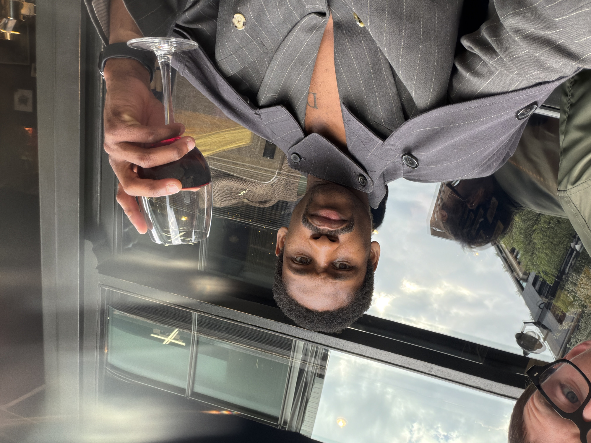 Man enjoys red wine in pinstripe suit in London