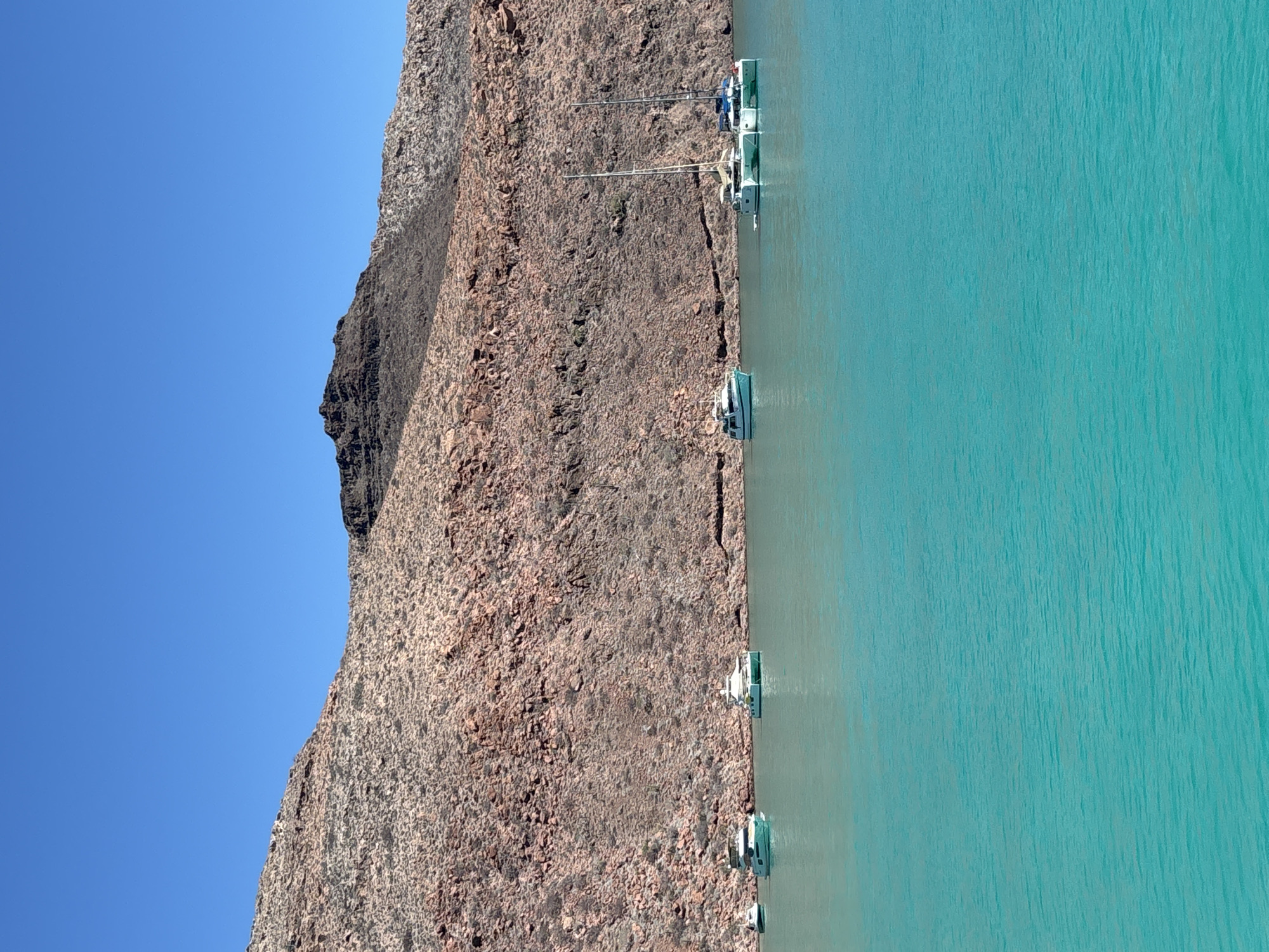 Evening boating activity observed along Mexico's rocky turquoise coastline