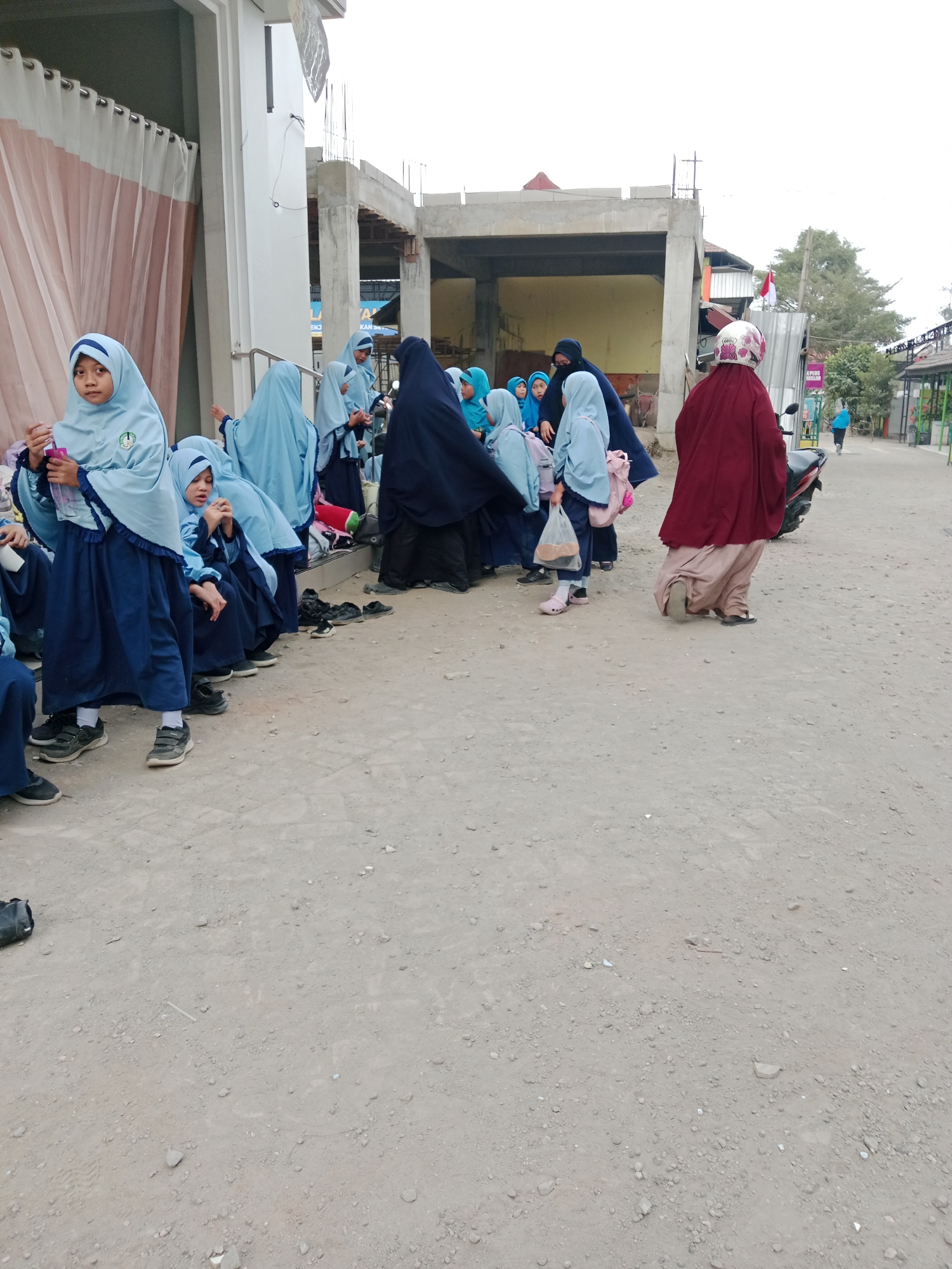 Students mill around a Kediri schoolyard on a weekday morning