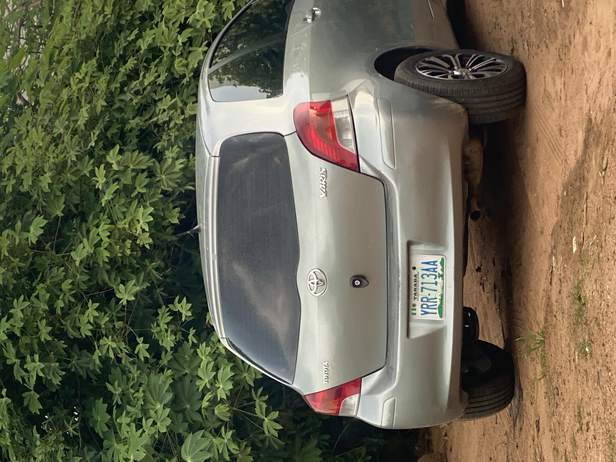 Multiple vehicles parked and attended to on Jalingo's dirt roads
