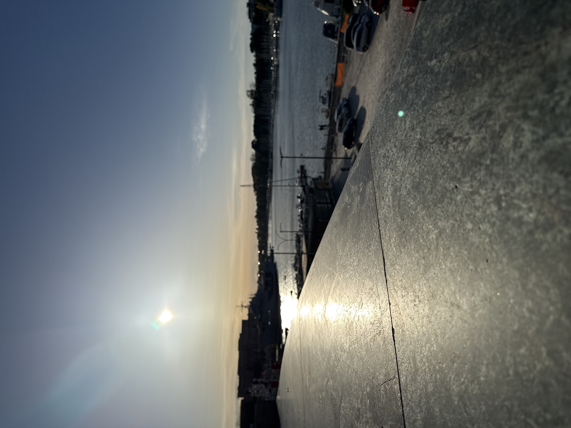 Sunset photographed over Brindisi harbor from elevated stone vantage point
